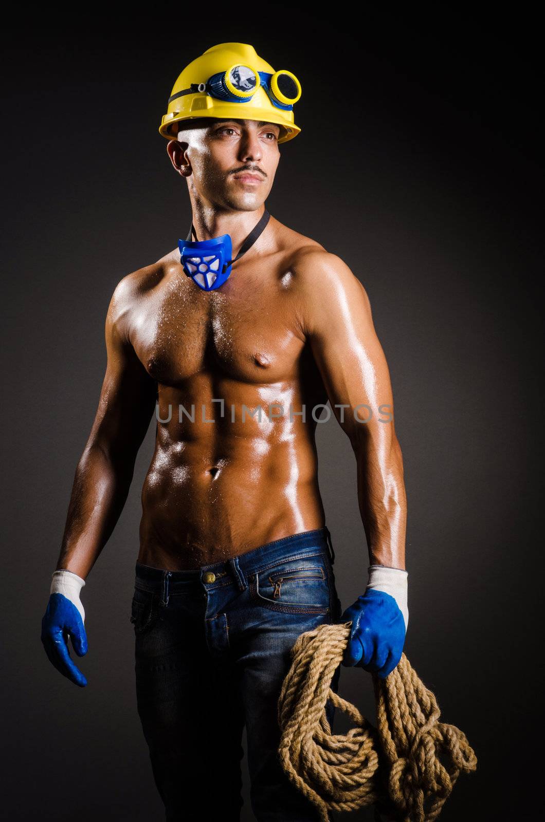 Construction worker in dark studio by Elnur