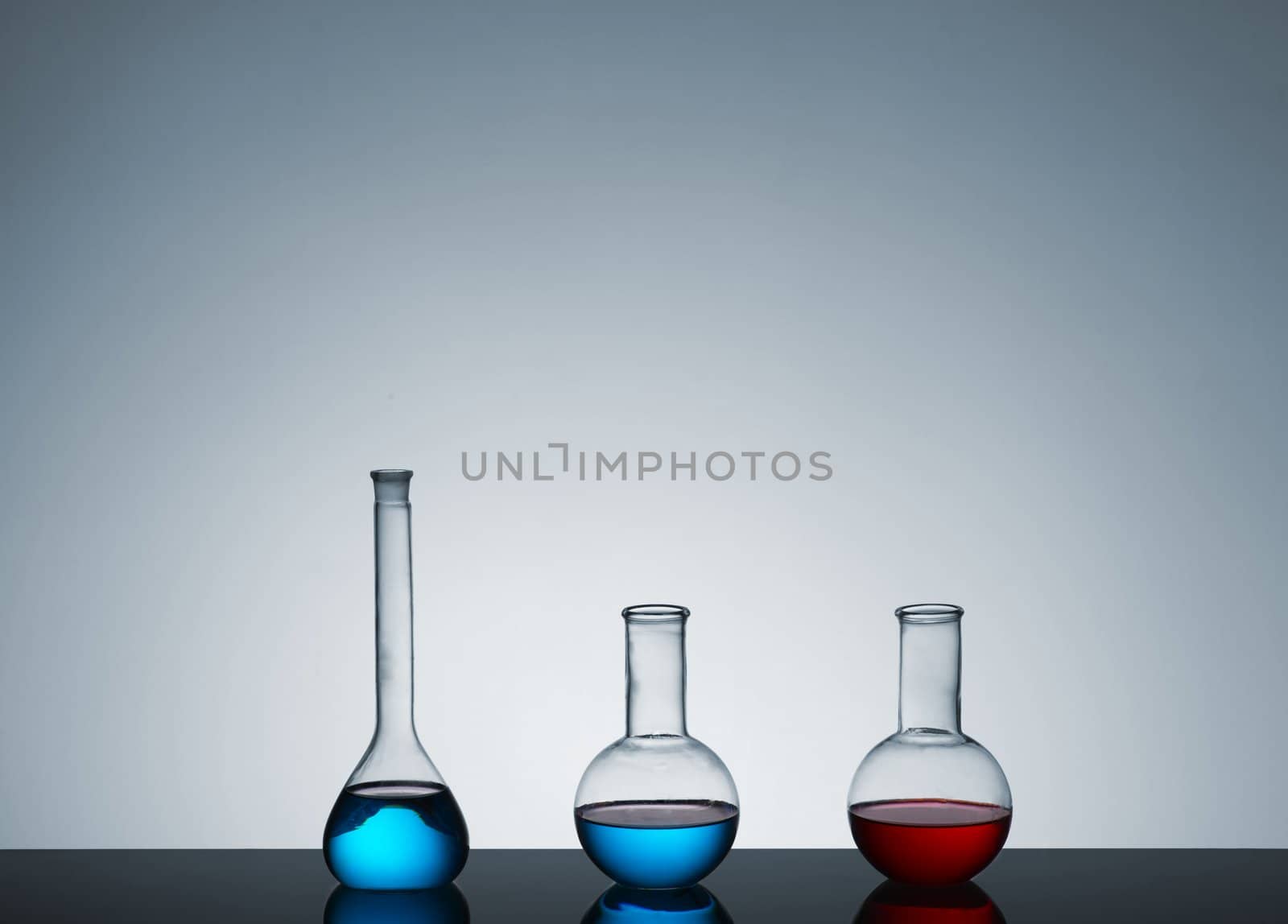 laboratory test tubes with colored liquid, place for text