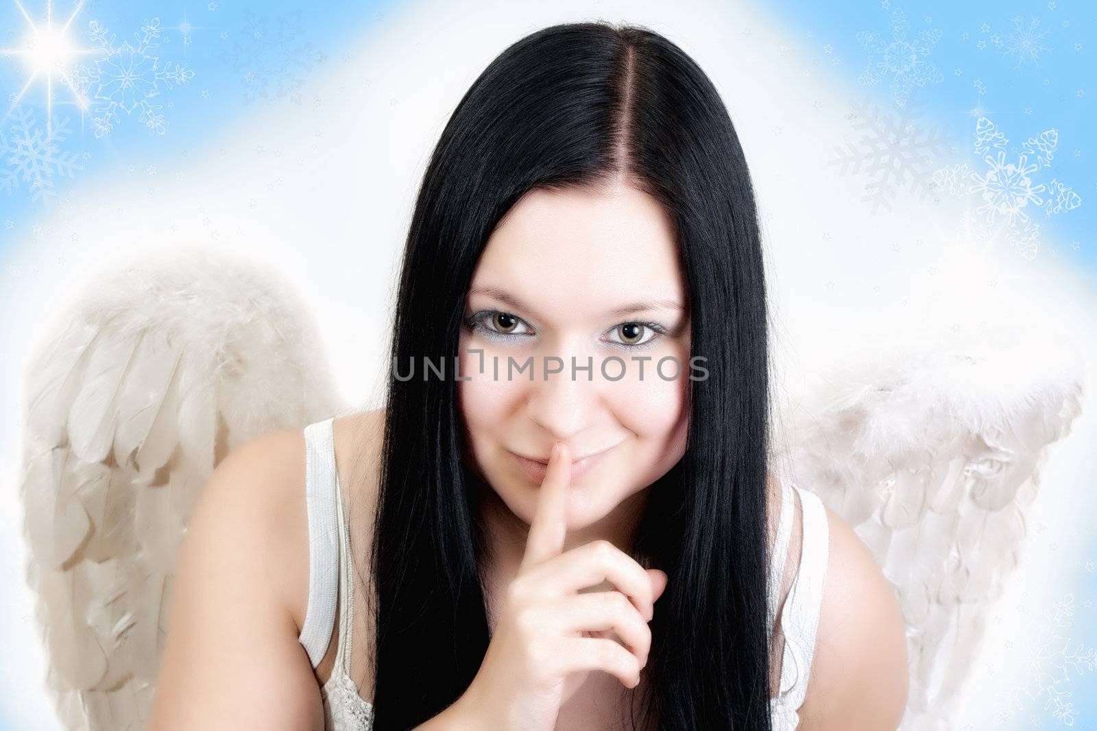 smiling christmas angel with black hair and wings holding finger on lips on white blue background with stars and snow