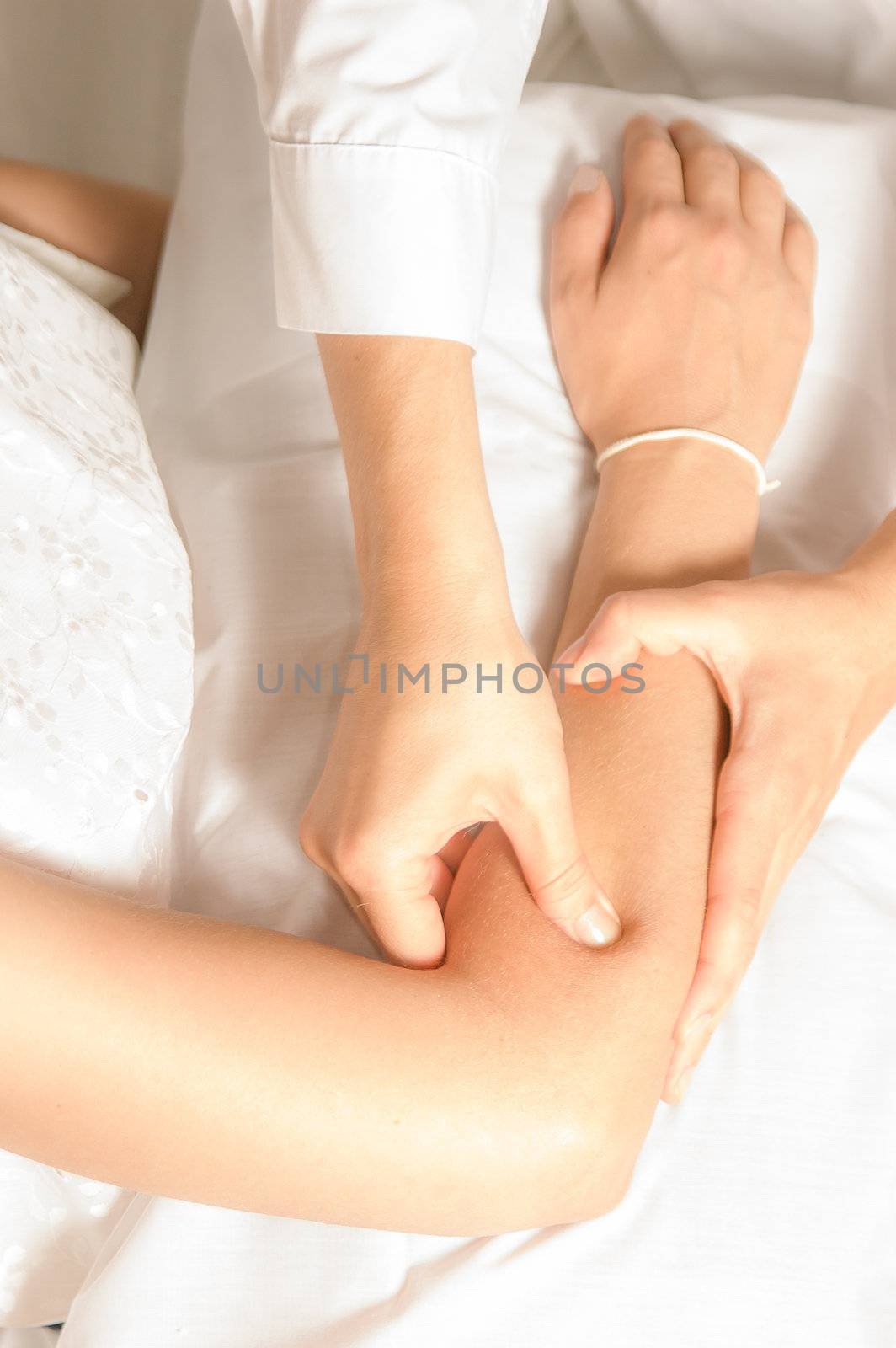 A physio gives myotherapy using trigger points on athlete woman