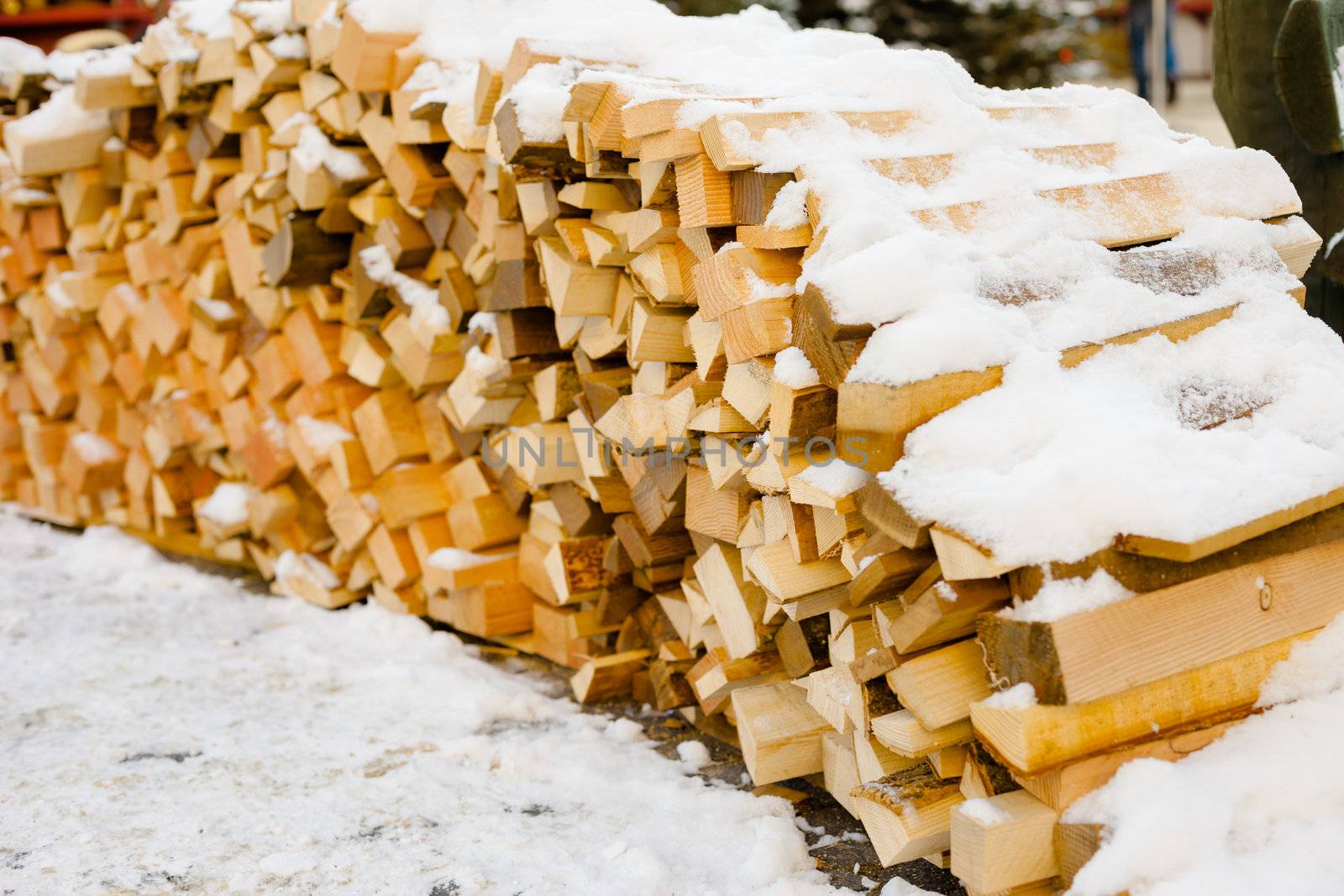 Pile of wood covered by snow after cutting