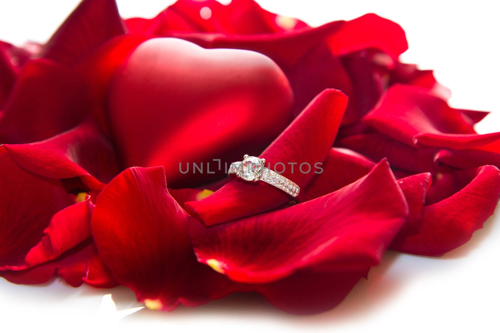 Golden diamond ring and red rose petals 
