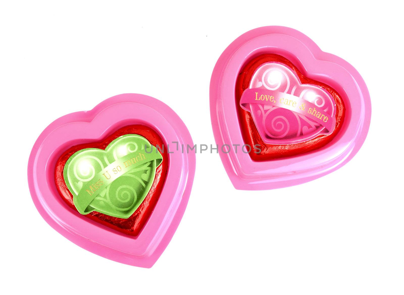 Wrapped red chocolate hearts on white background by geargodz