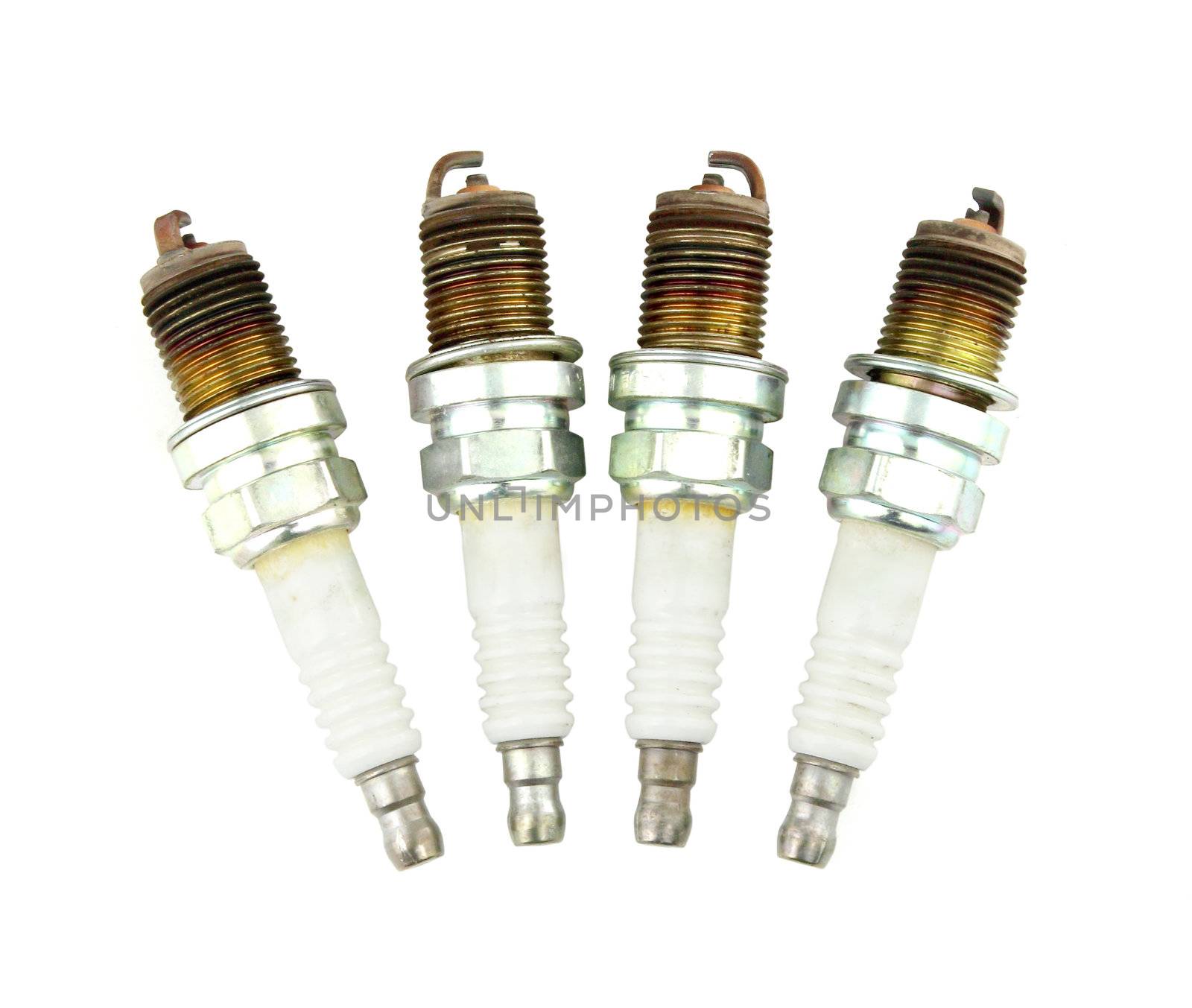 four old burned spark plug on white background by geargodz