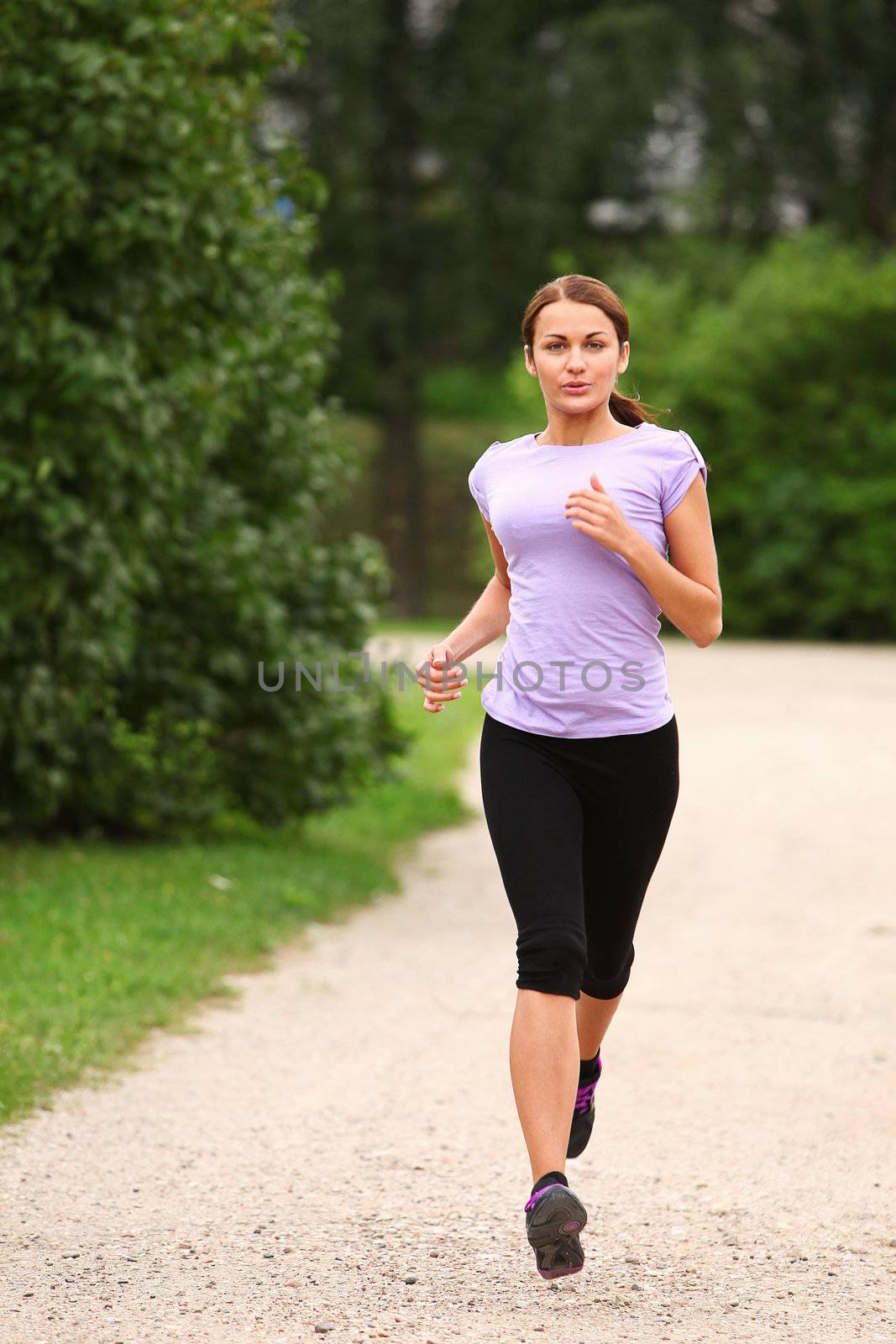 Young and attractive sporty girl running in the park