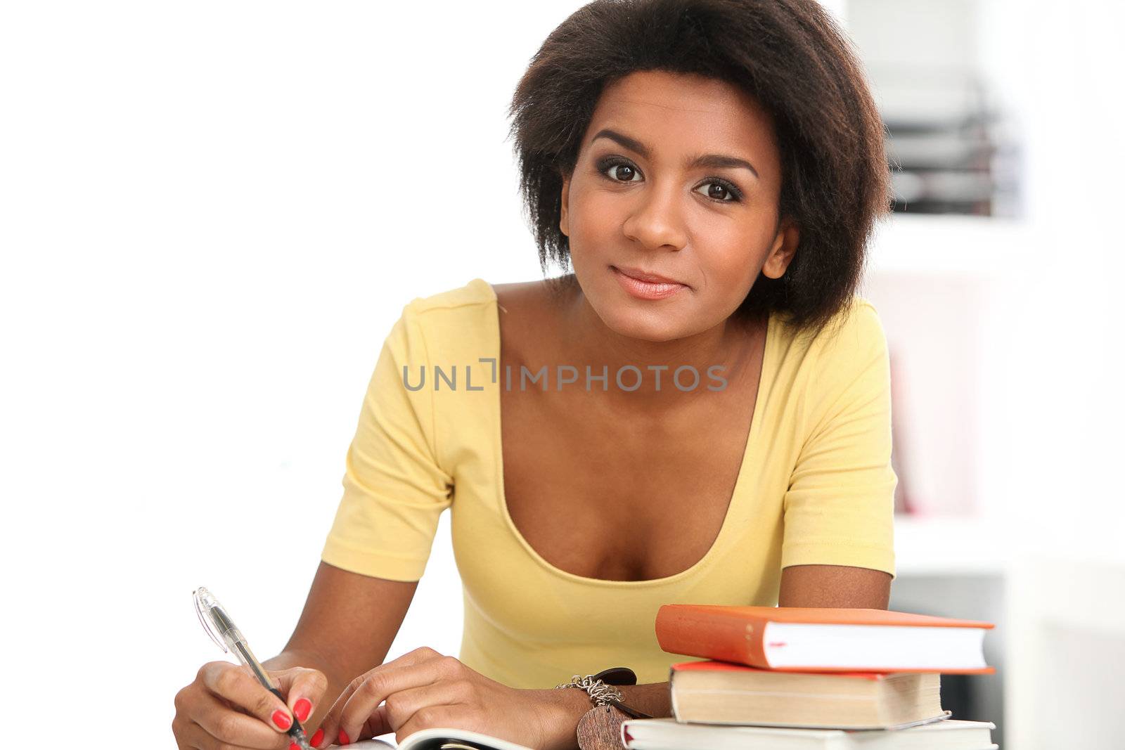 Young and beautiful afro woman studying with books