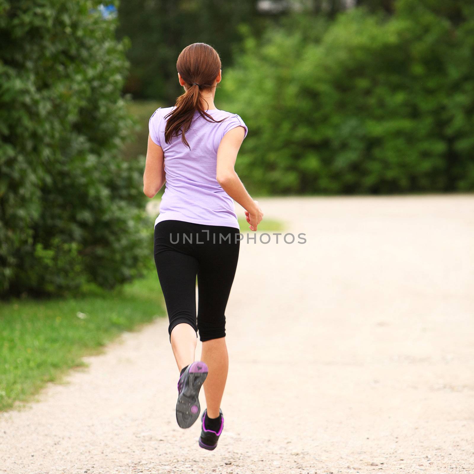 Young and attractive sporty girl running in the park