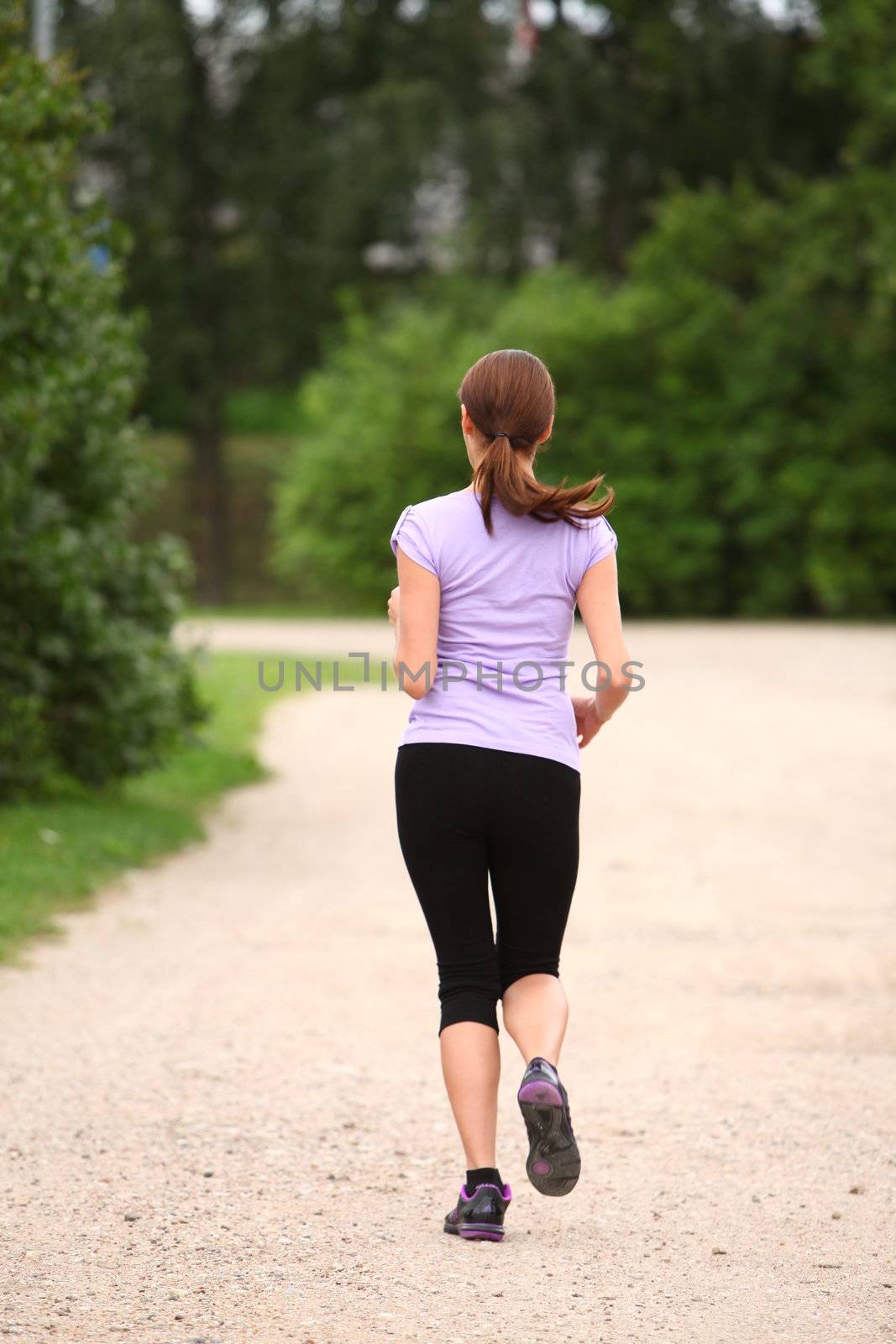 Young and attractive sporty girl running in the park