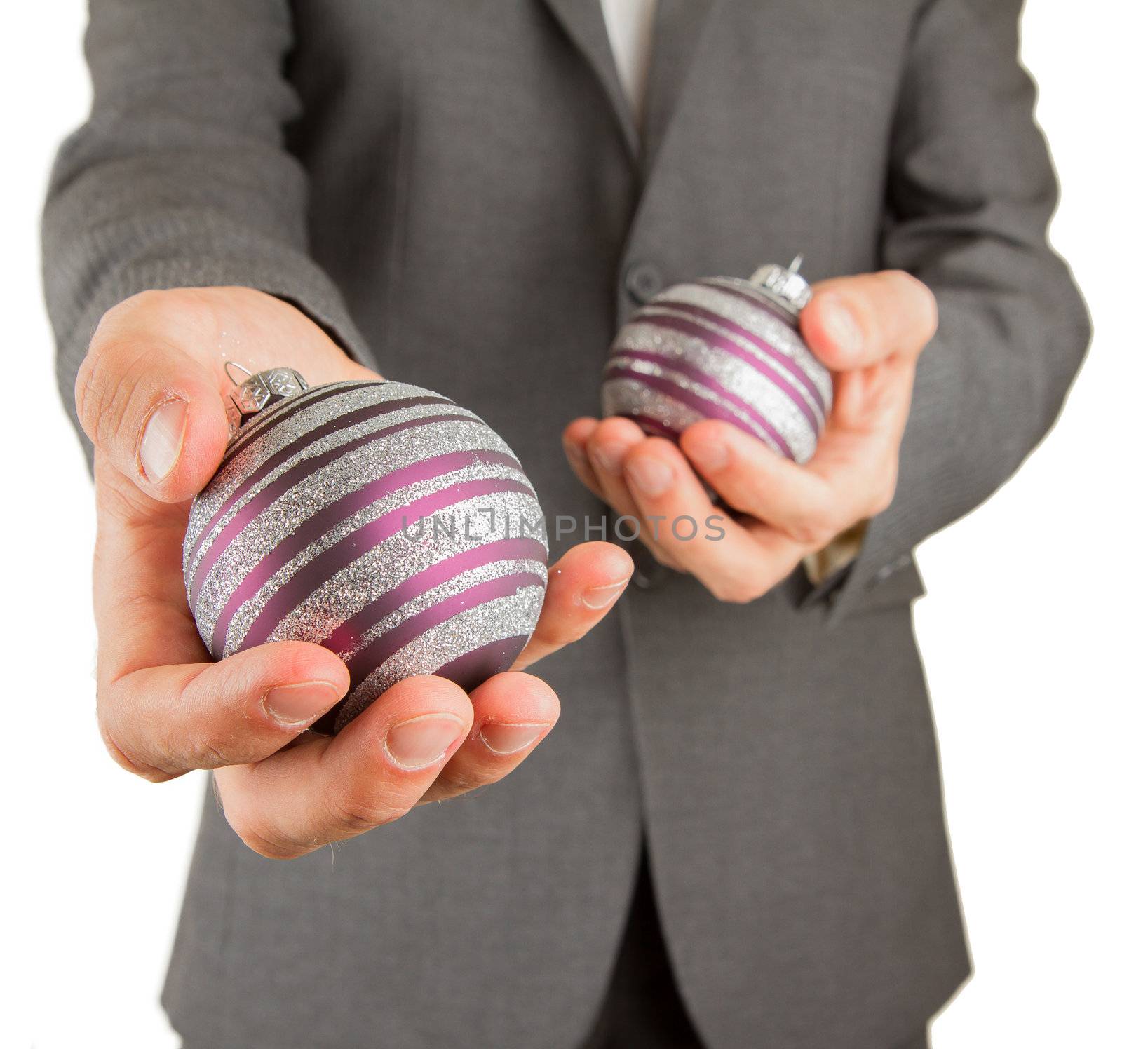 Man in grey suit is holding Christmass balls, isolated