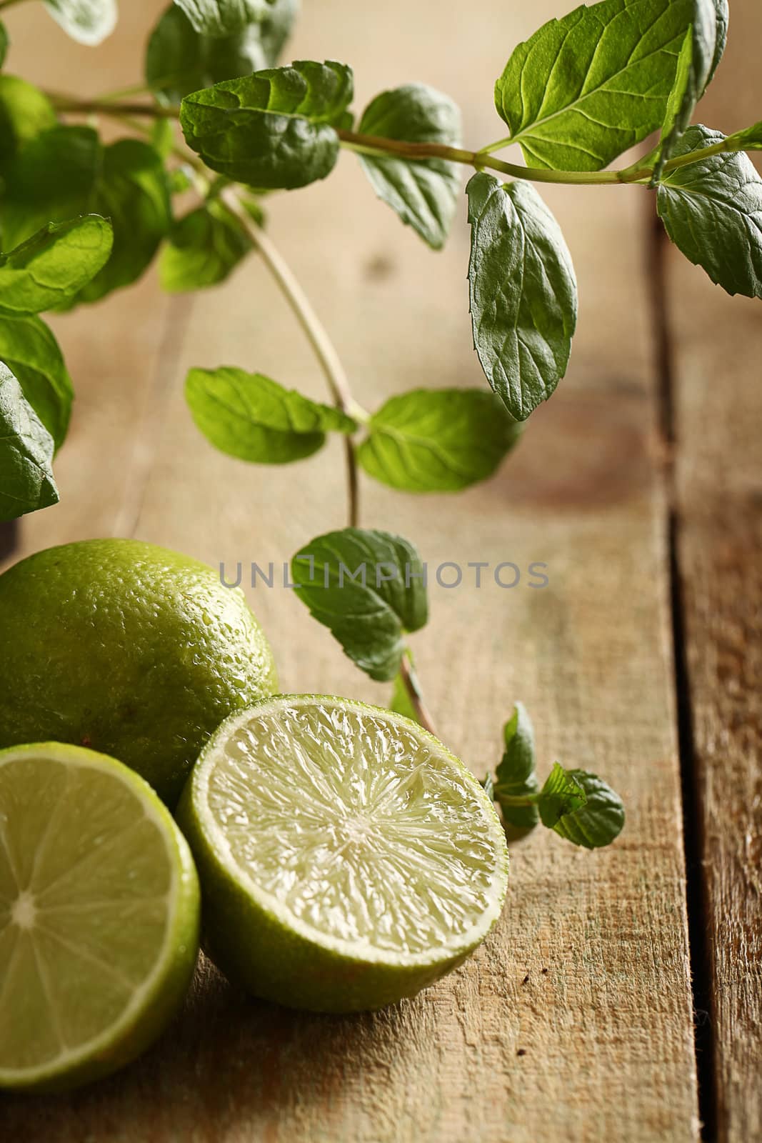 Fresh sliced lime with green mint on a wooden surface