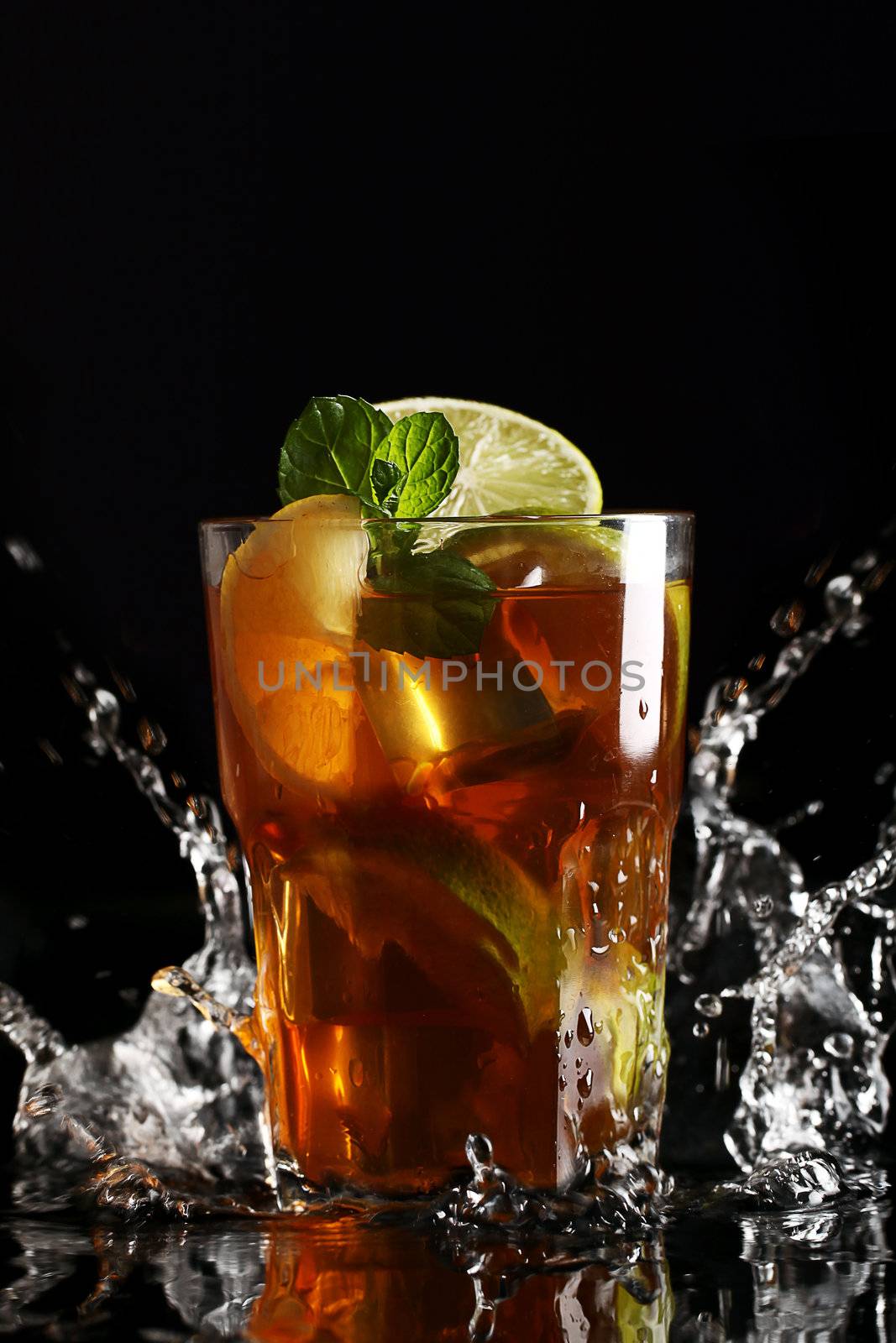 Fresh cold tea with lemon, lime and mint in water splashing