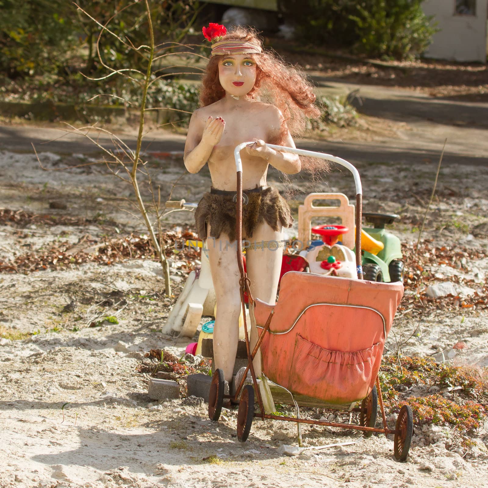 An old plastic statue of a woman with a childrens buggy