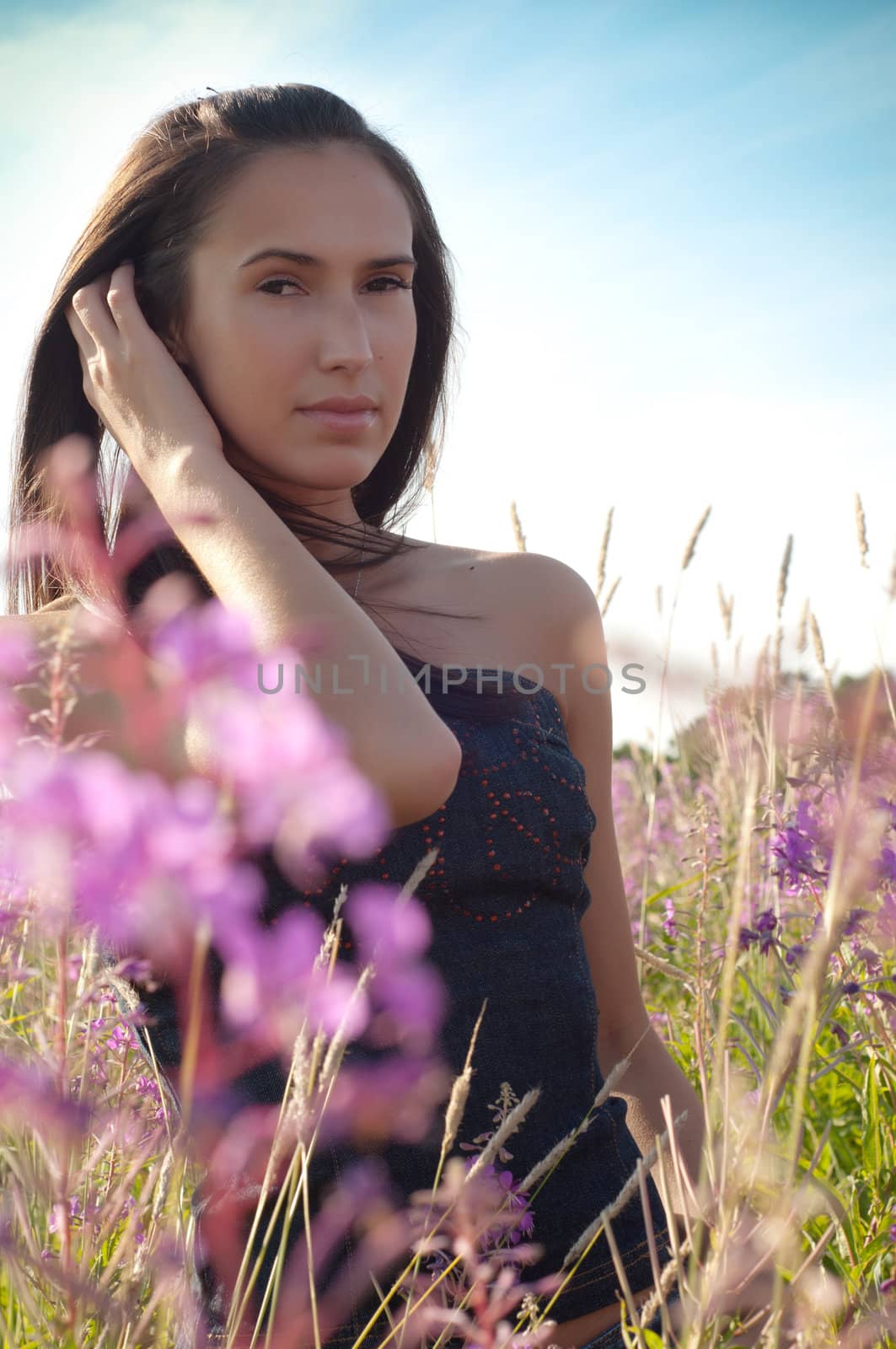 Beautiful brunette woman in pink flowers by anytka
