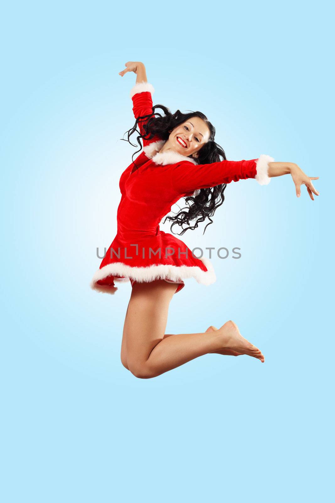 Happy smiling woman in red xmas costume jumping high