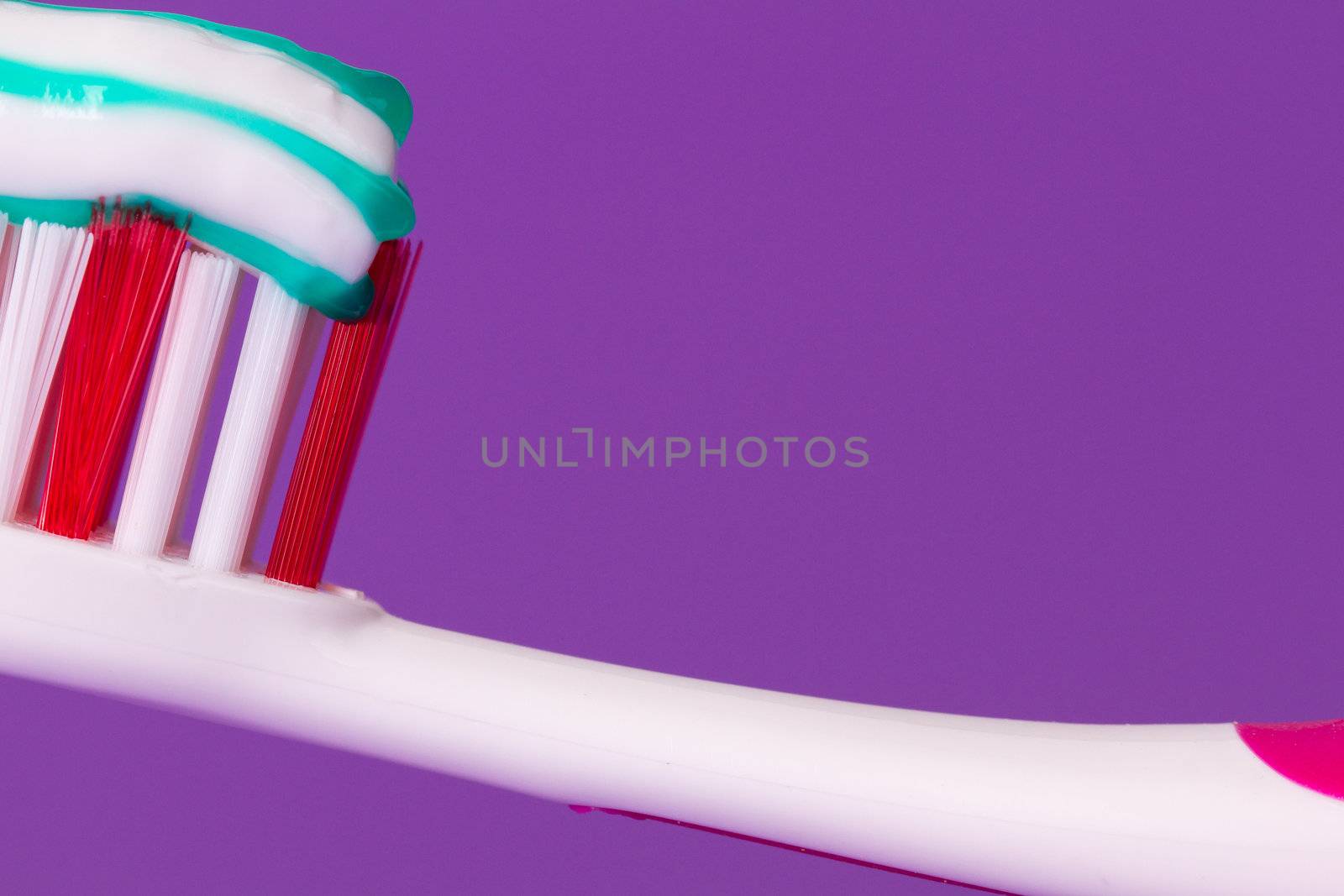 A pink toothbrush with toothpaste by michaklootwijk