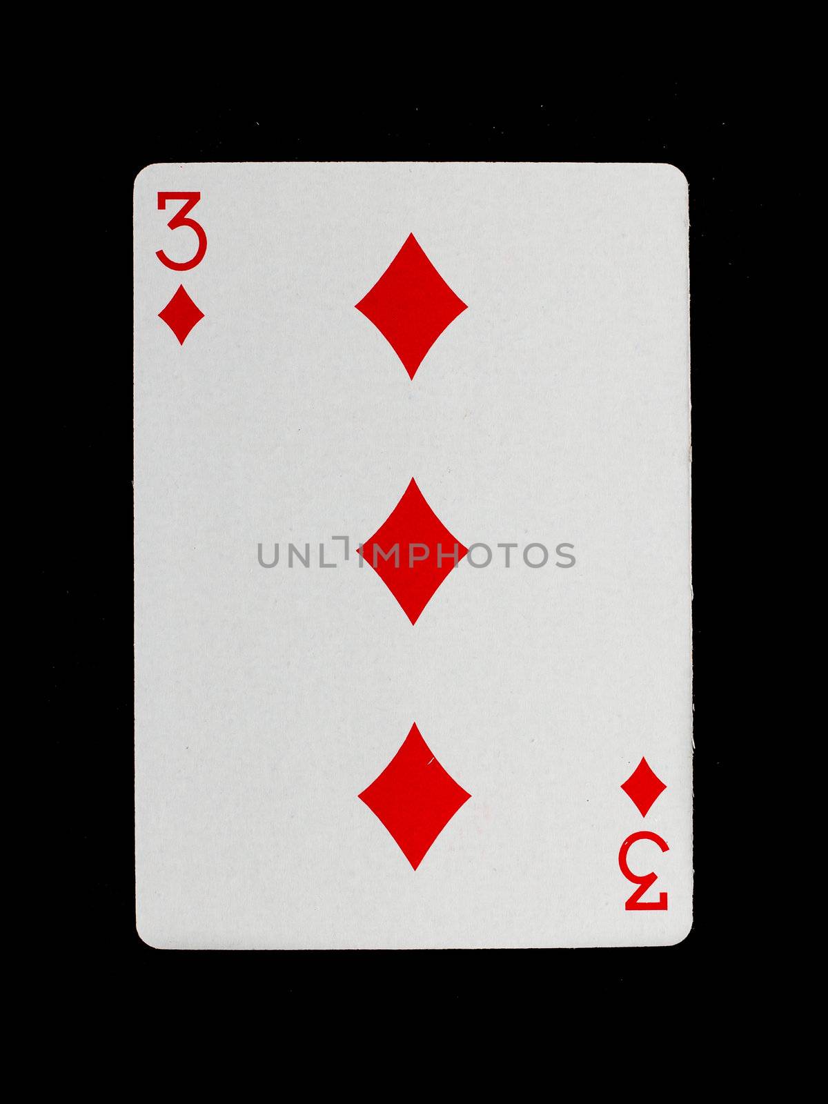 Old playing card (three) isolated on a black background