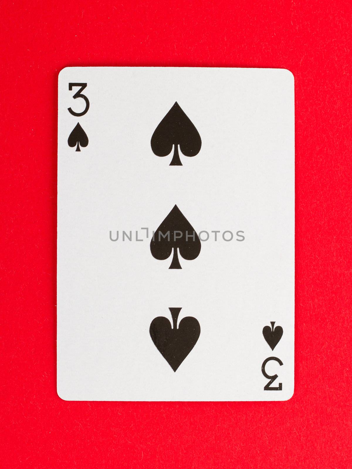 Playing card (three) isolated on a red background