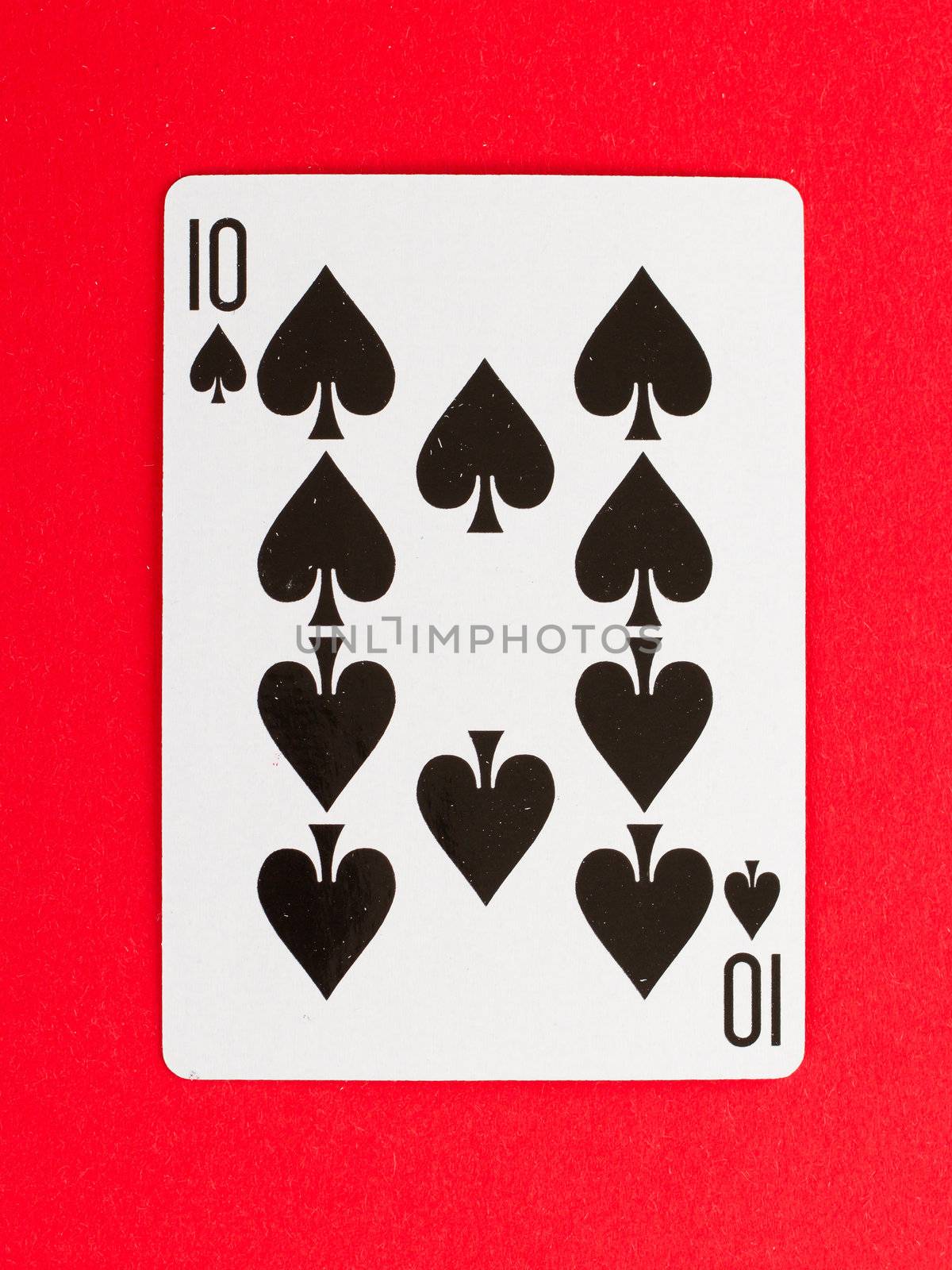 Old playing card (ten) isolated on a red background