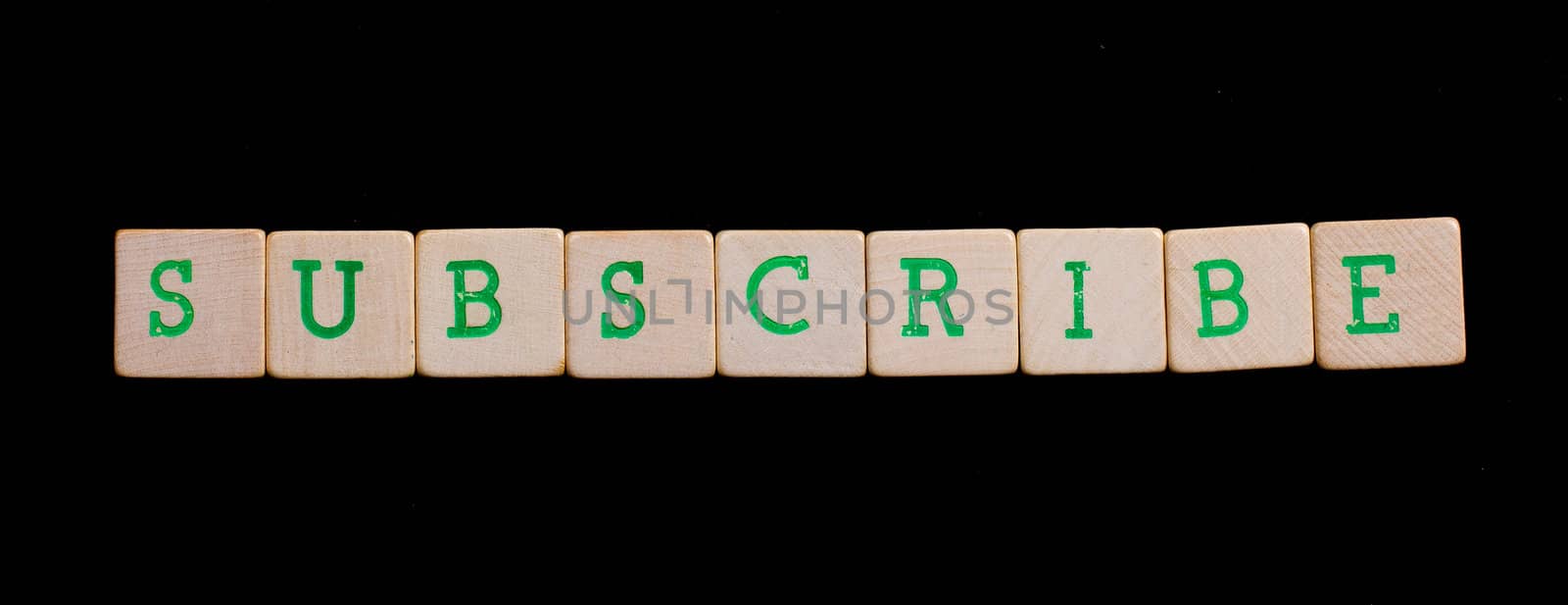 Green letters on old wooden blocks (subscribe) by michaklootwijk