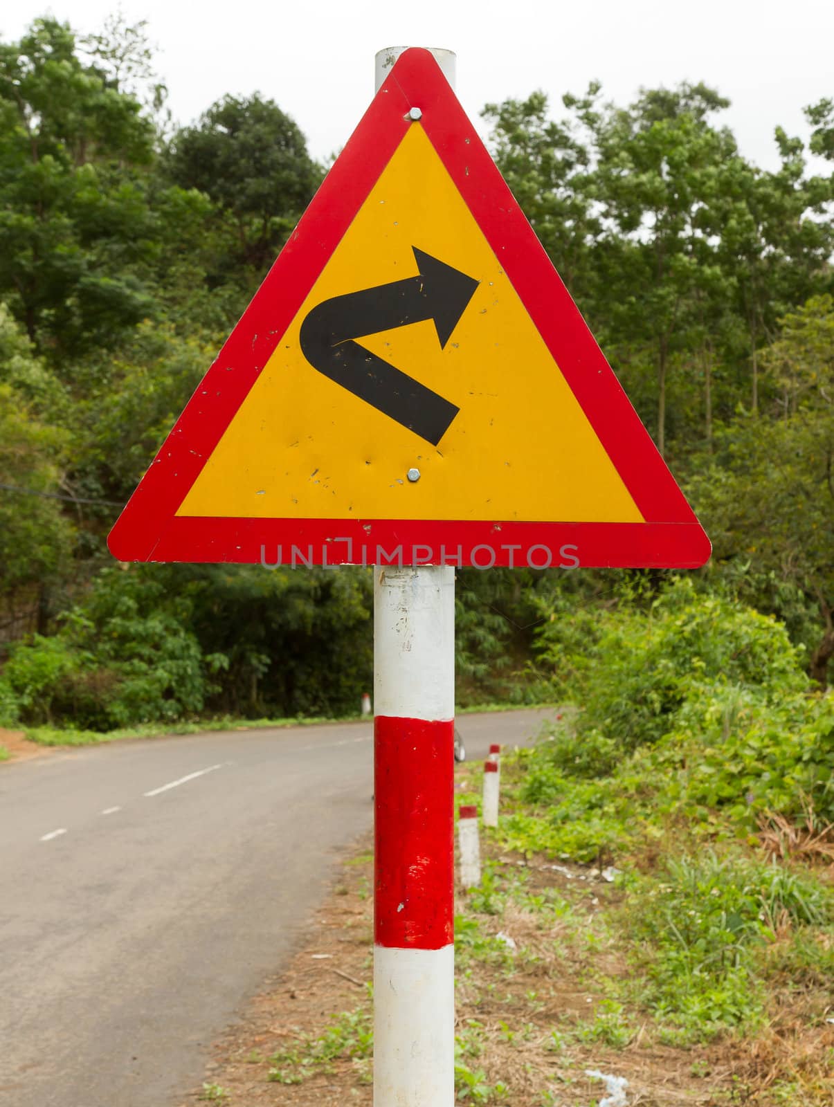 Bending roadtraffic sign on a road in the south of Vietnam