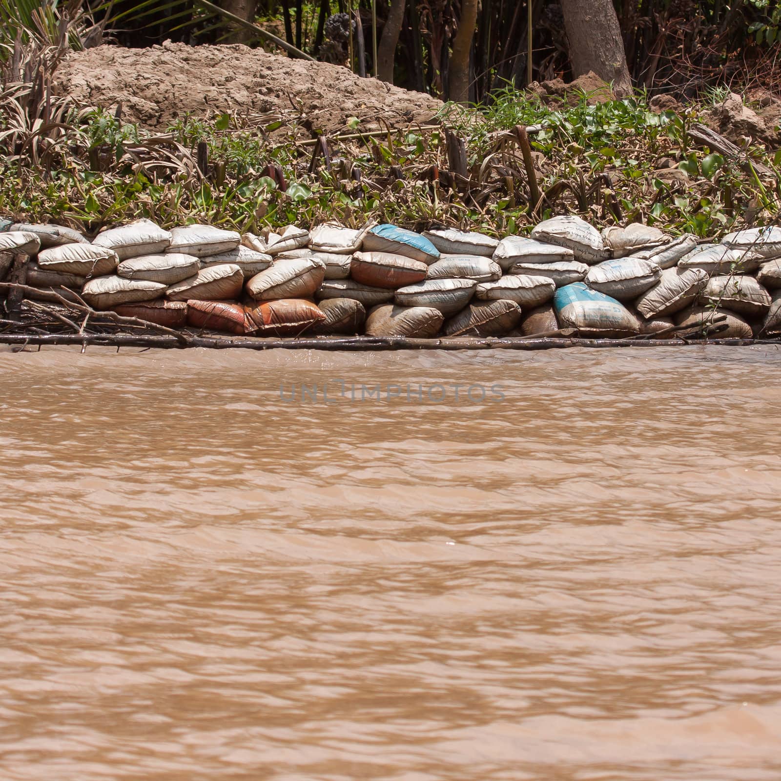 Dike made from sandbags erected to prevent the Mekong Delta from flooding one of the islands