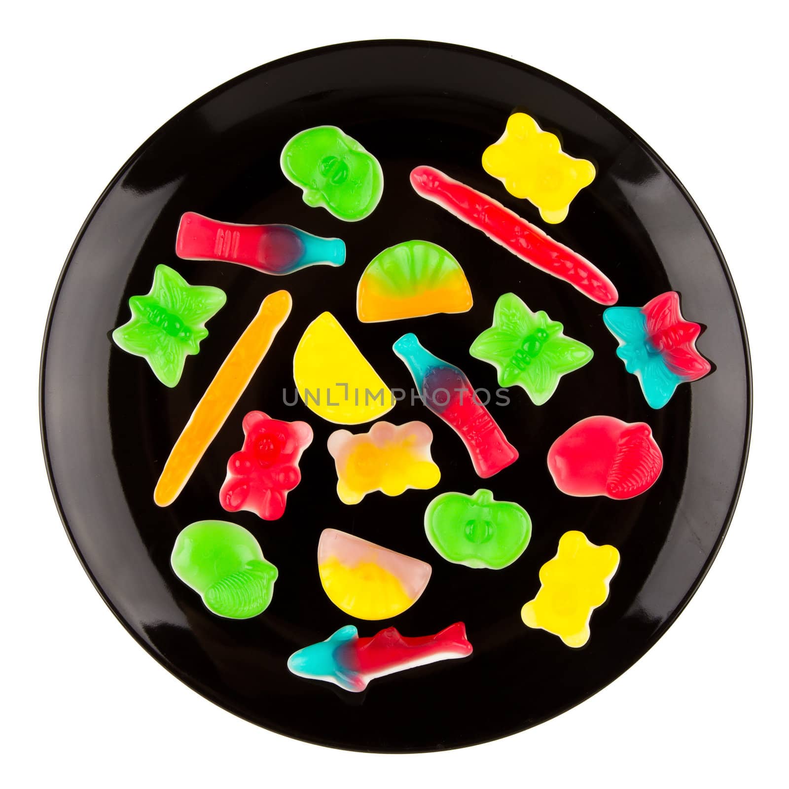 Colorful candies in many different shapes isolated on a black plate, isolated on white