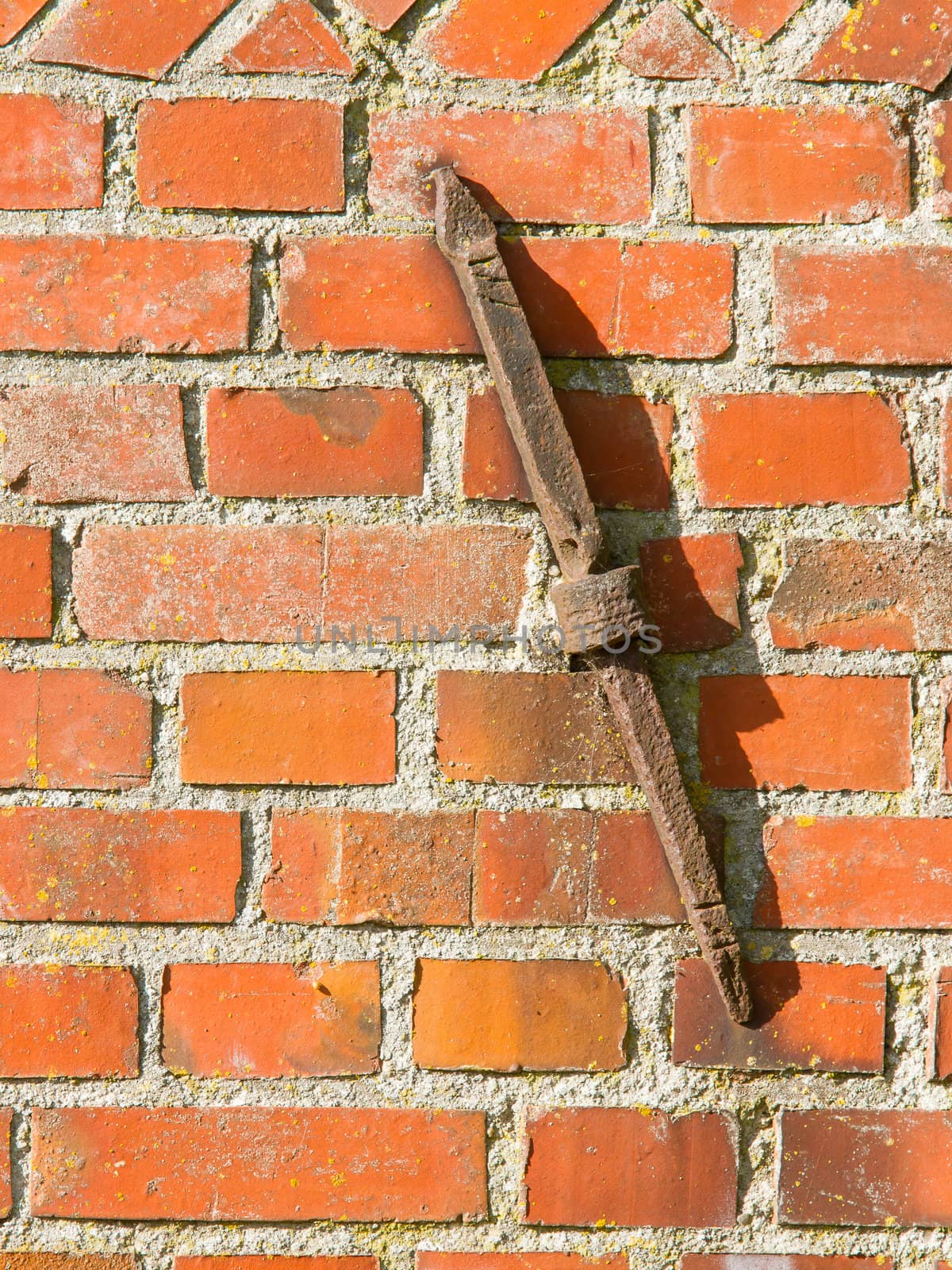 Old rusty clamp in a brick wall, isolated