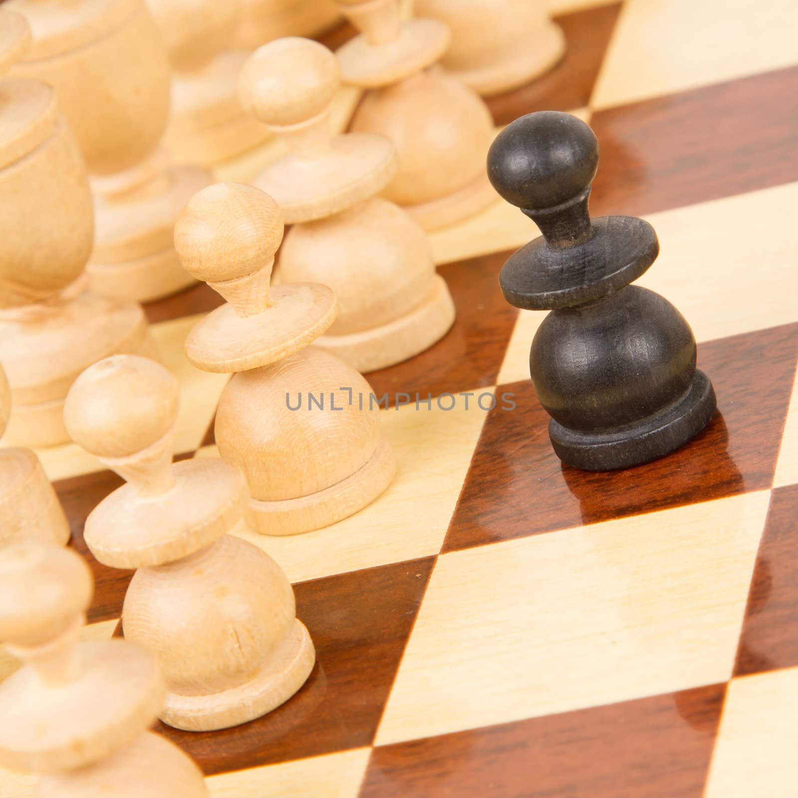 Black pawn on a wooden chessboard by michaklootwijk