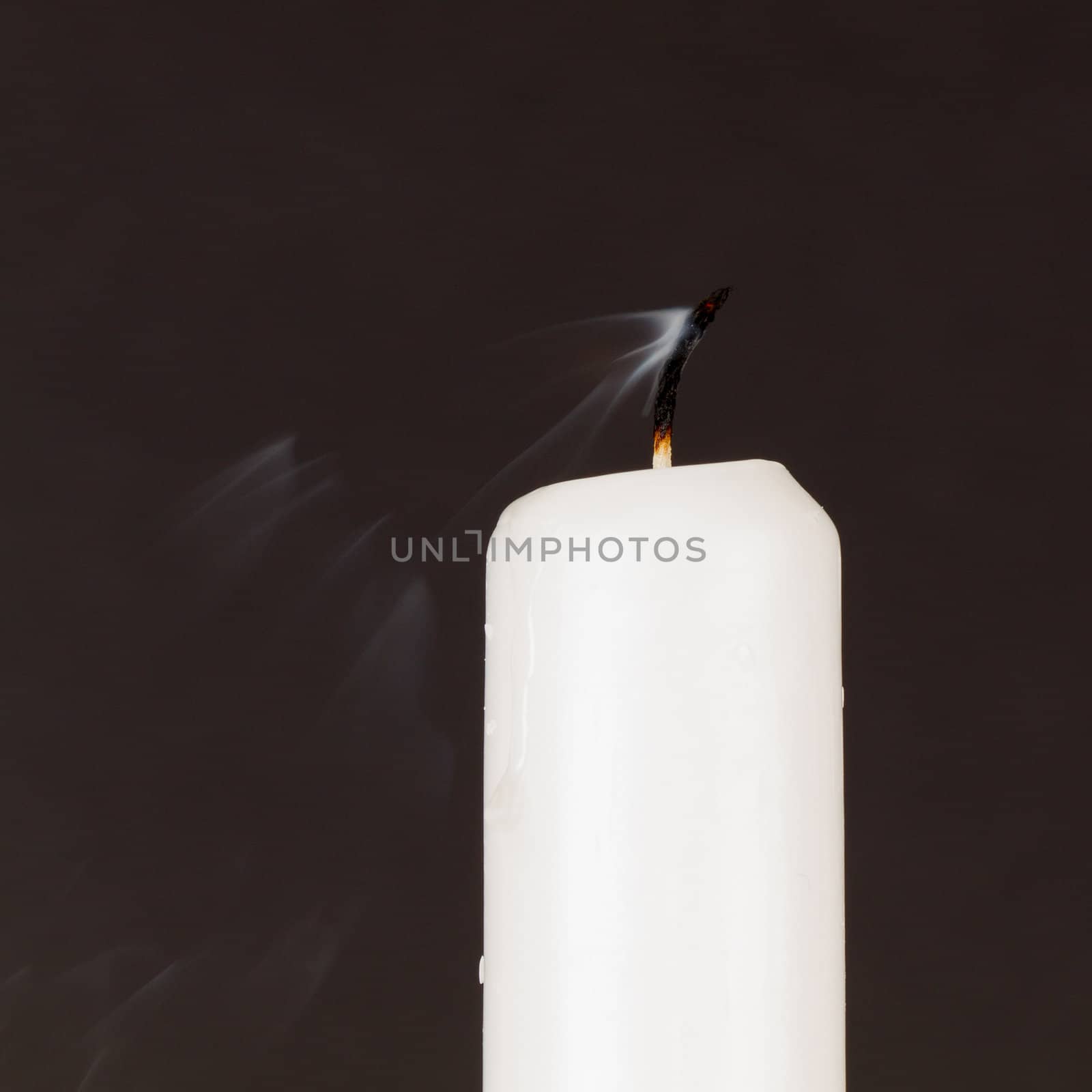 White candle isolated against a black background