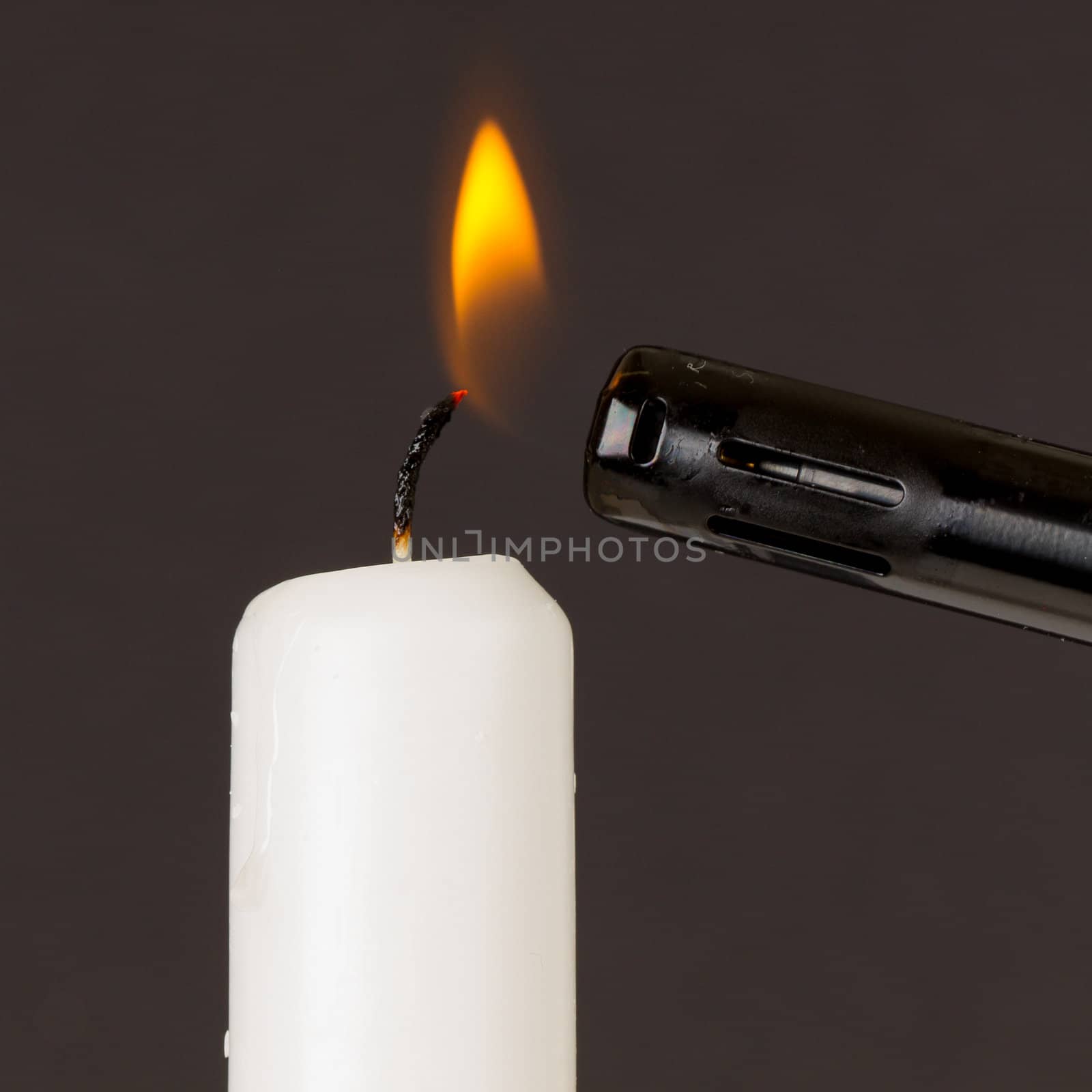 White candle isolated against a black background