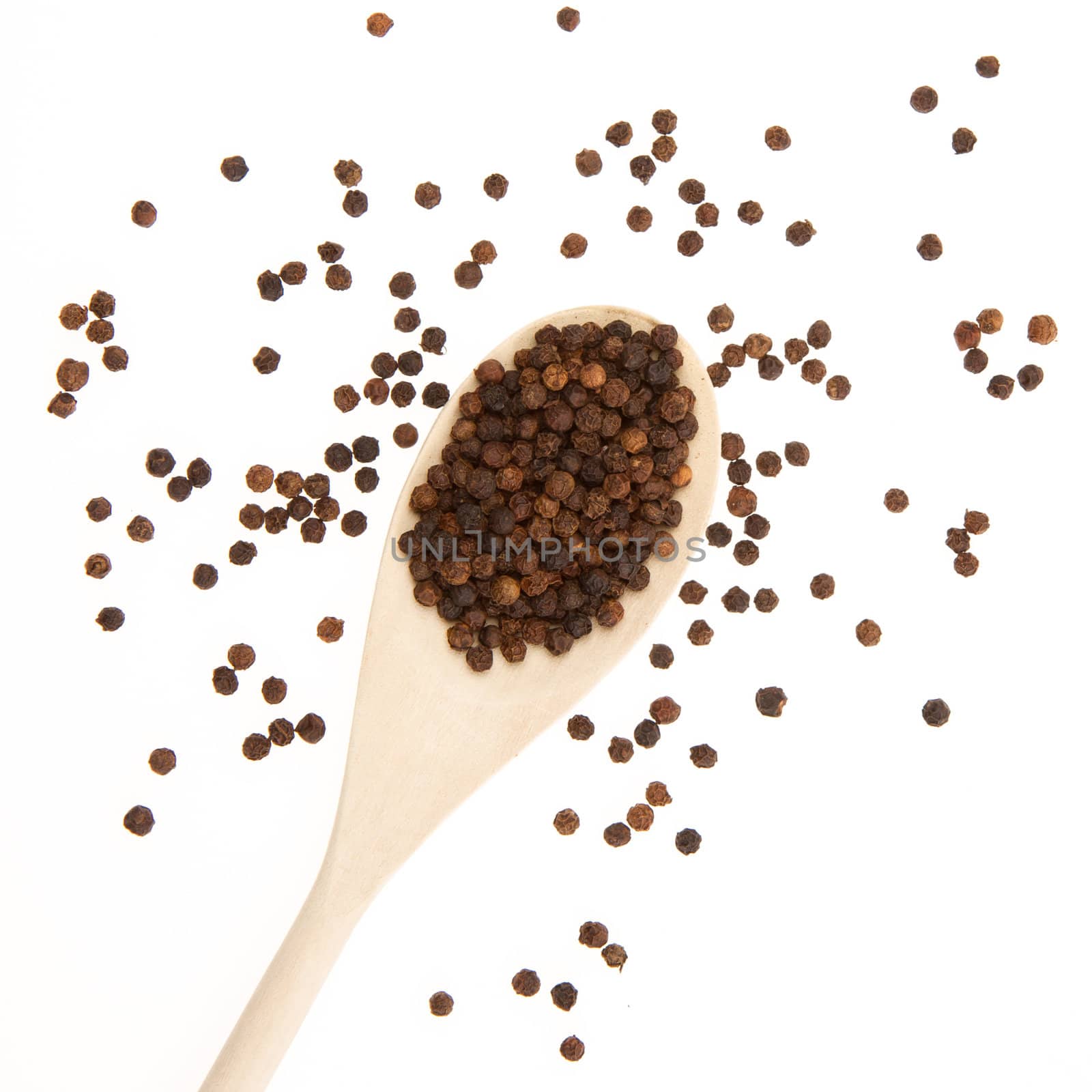 Black pepper on a wooden spoon by michaklootwijk