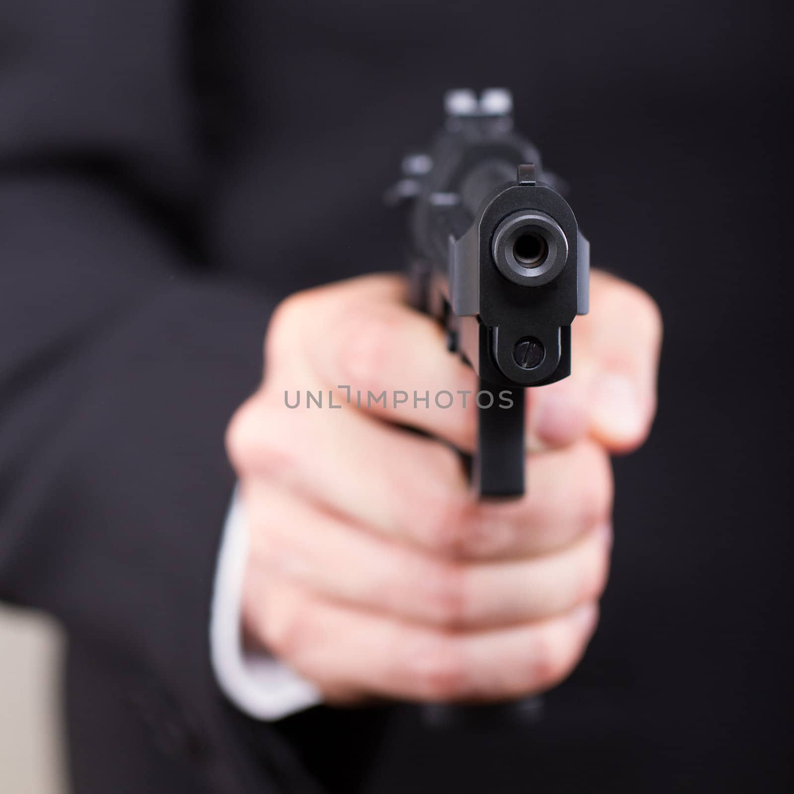 Man with gun, business suit, focus on the gun