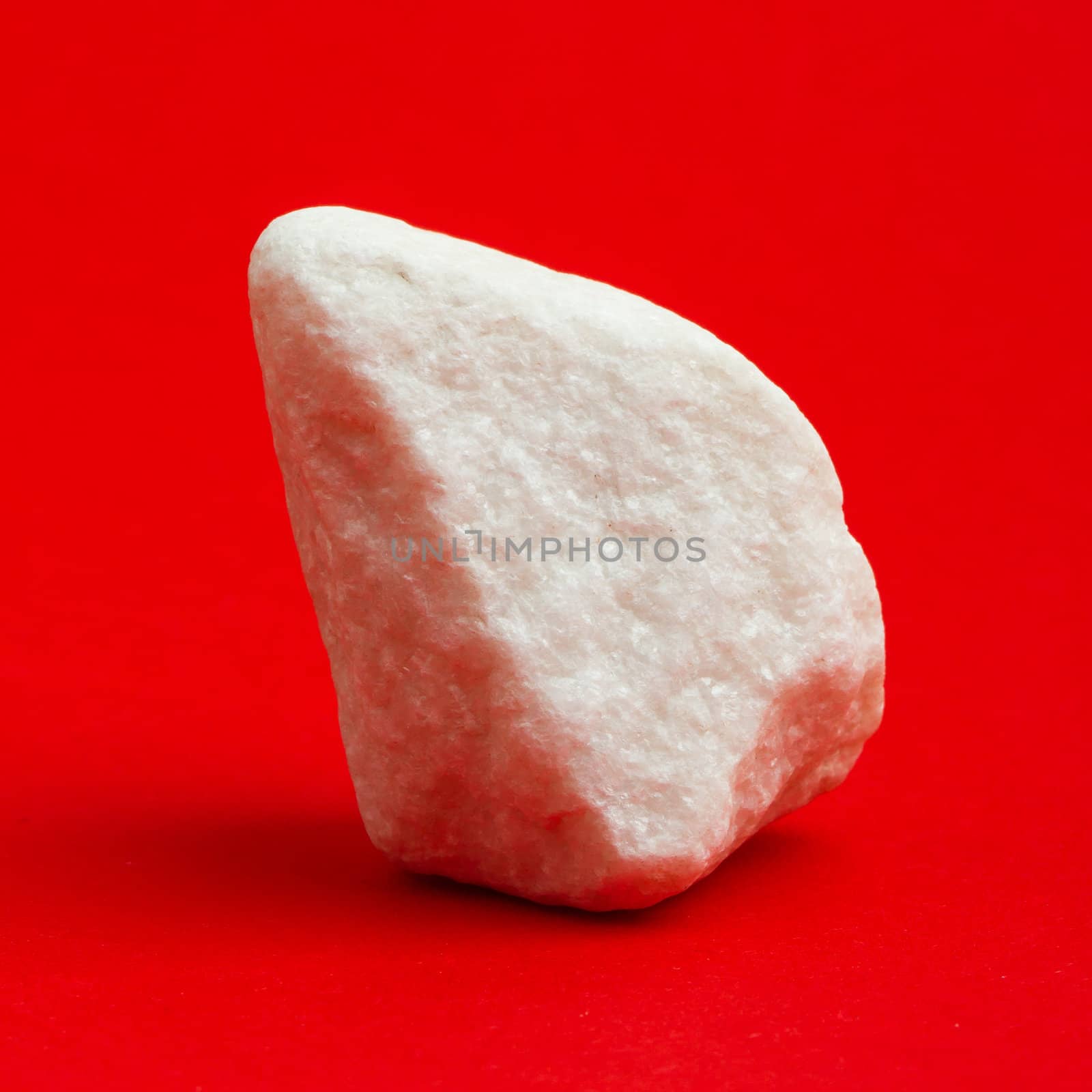 Glittering white stone isolated on a red background