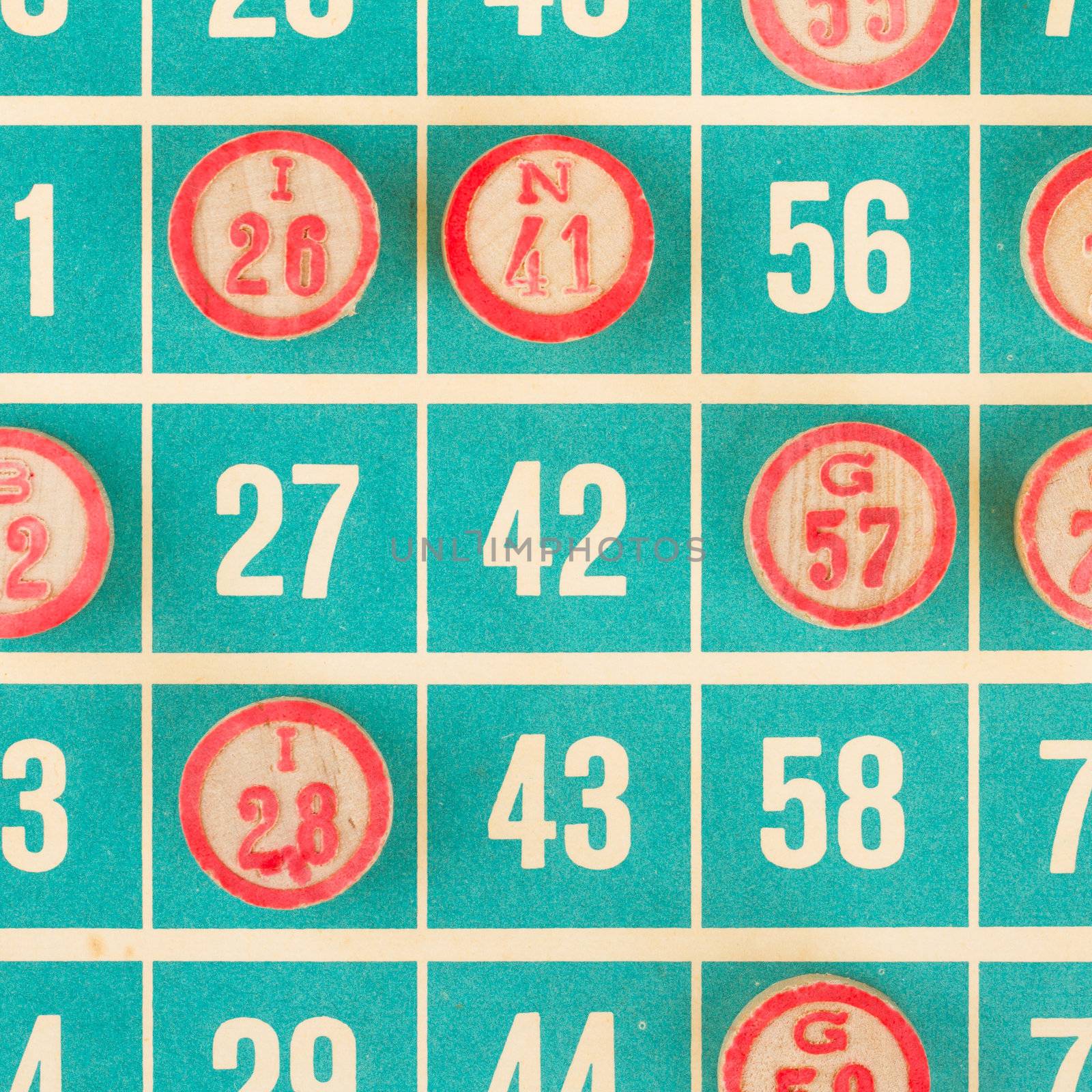 Wooden numbers used for bingo, on top of a bingo card