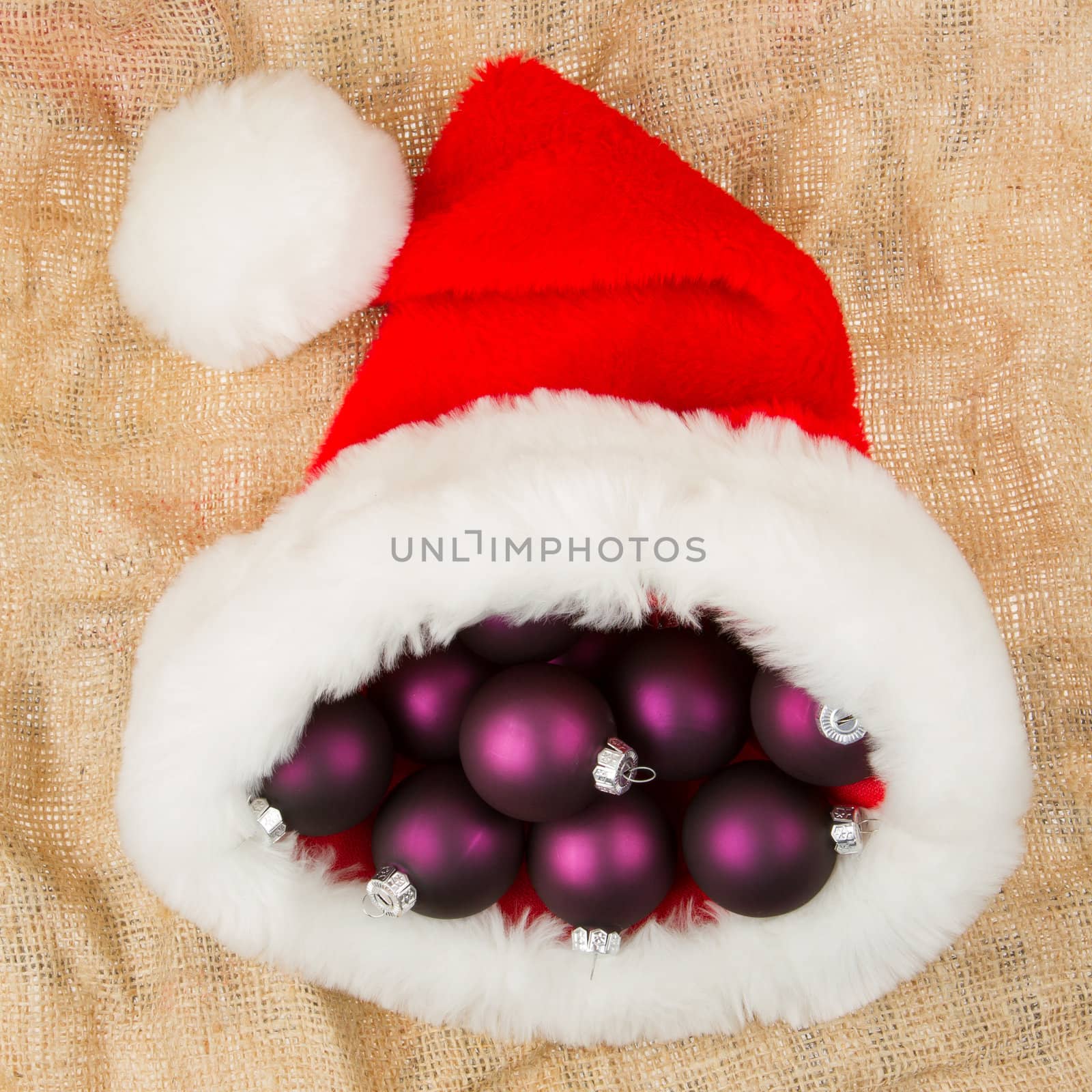 Santas hat filled with Christmas purple balls