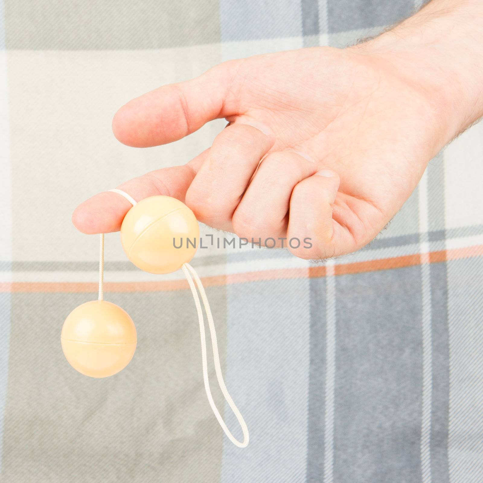 Hand holding vaginal balls, isolated on an old quilt