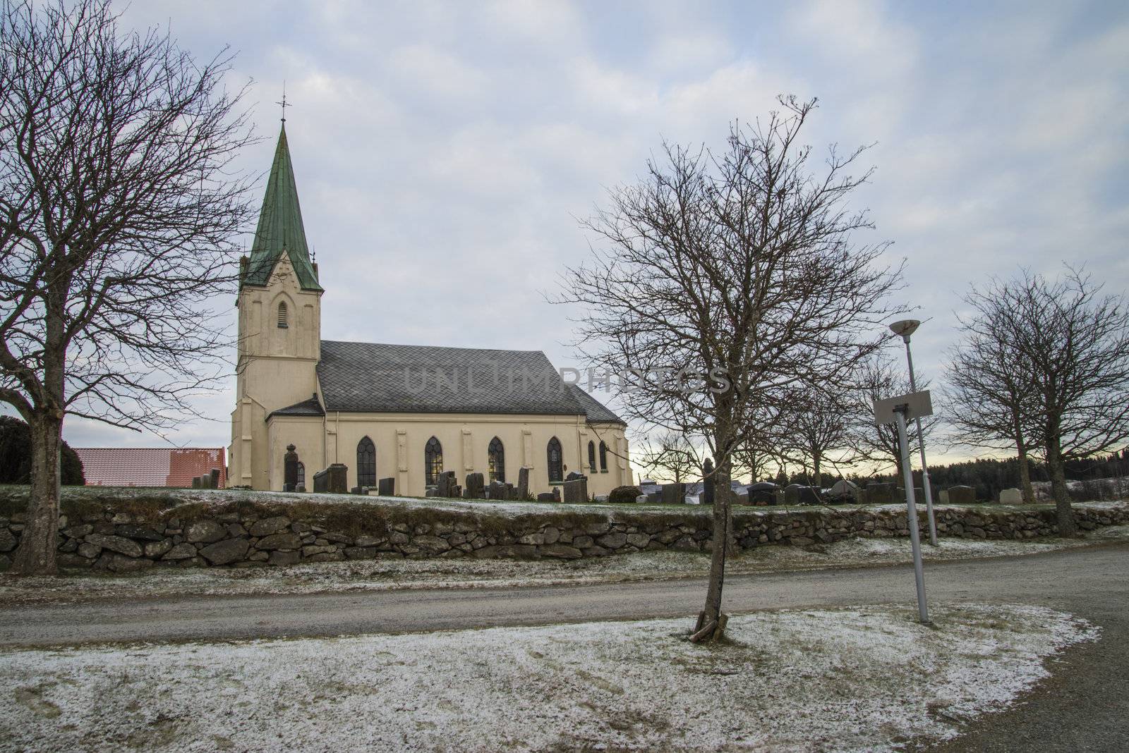 asak is a village and typical agricultural area in the municipality of halden and here are located asak church which is a long church from 1893. the building is in brick and has 400 seats and is in new gothic style. there are graveyard at the church, the picture is shot in december 2012