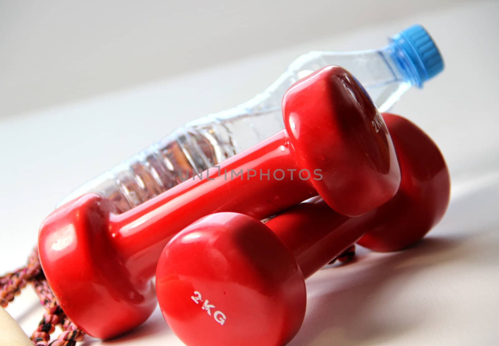 Red dumbbells and bottle of water