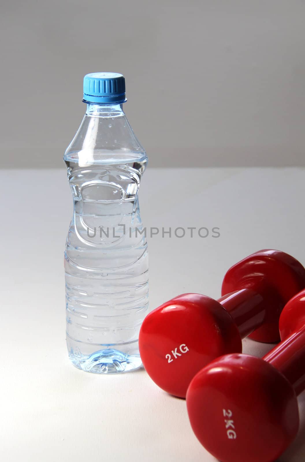 Red dumbbells and bottle of water