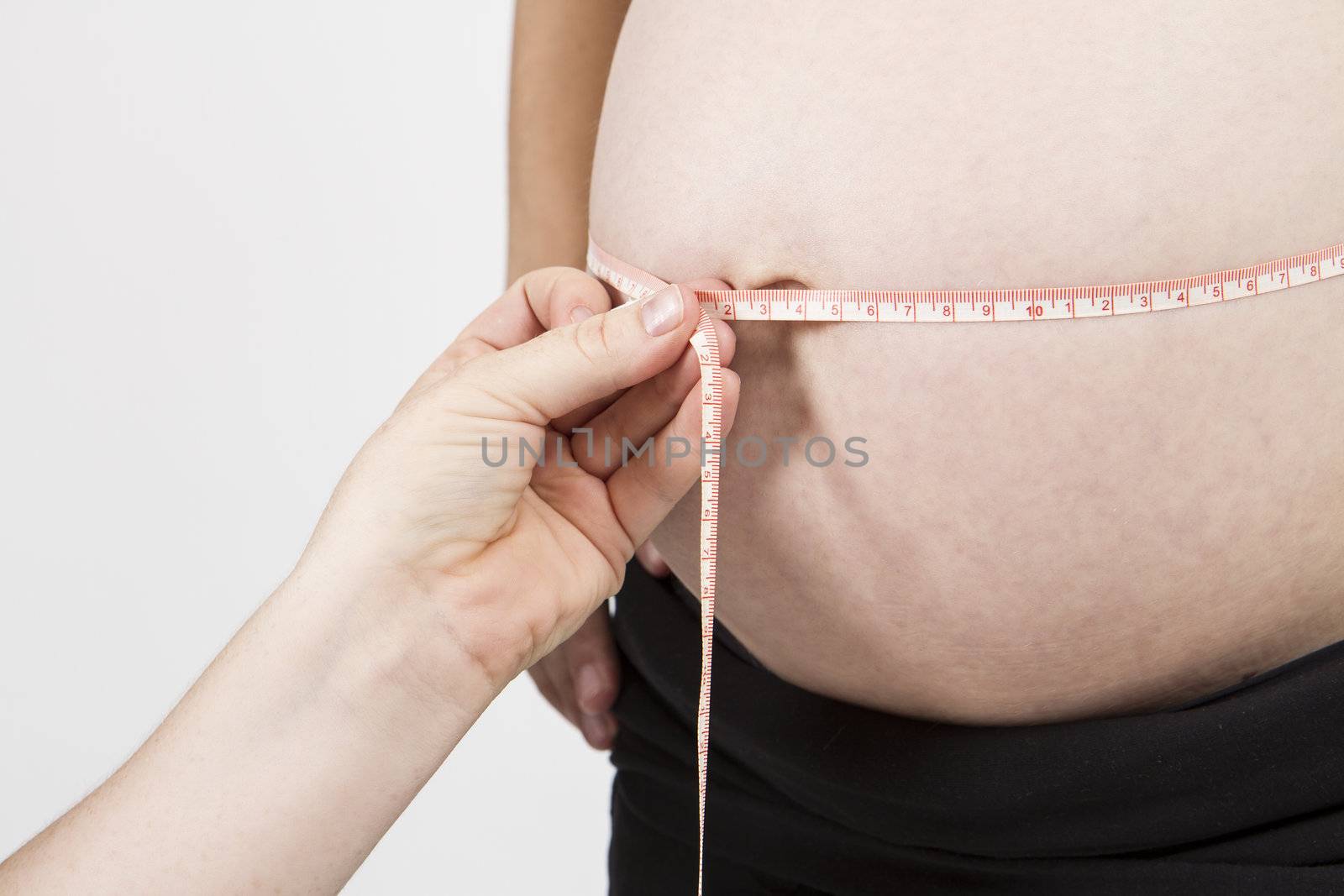 hand of midwife measuring pregnant belly. horizontal picture