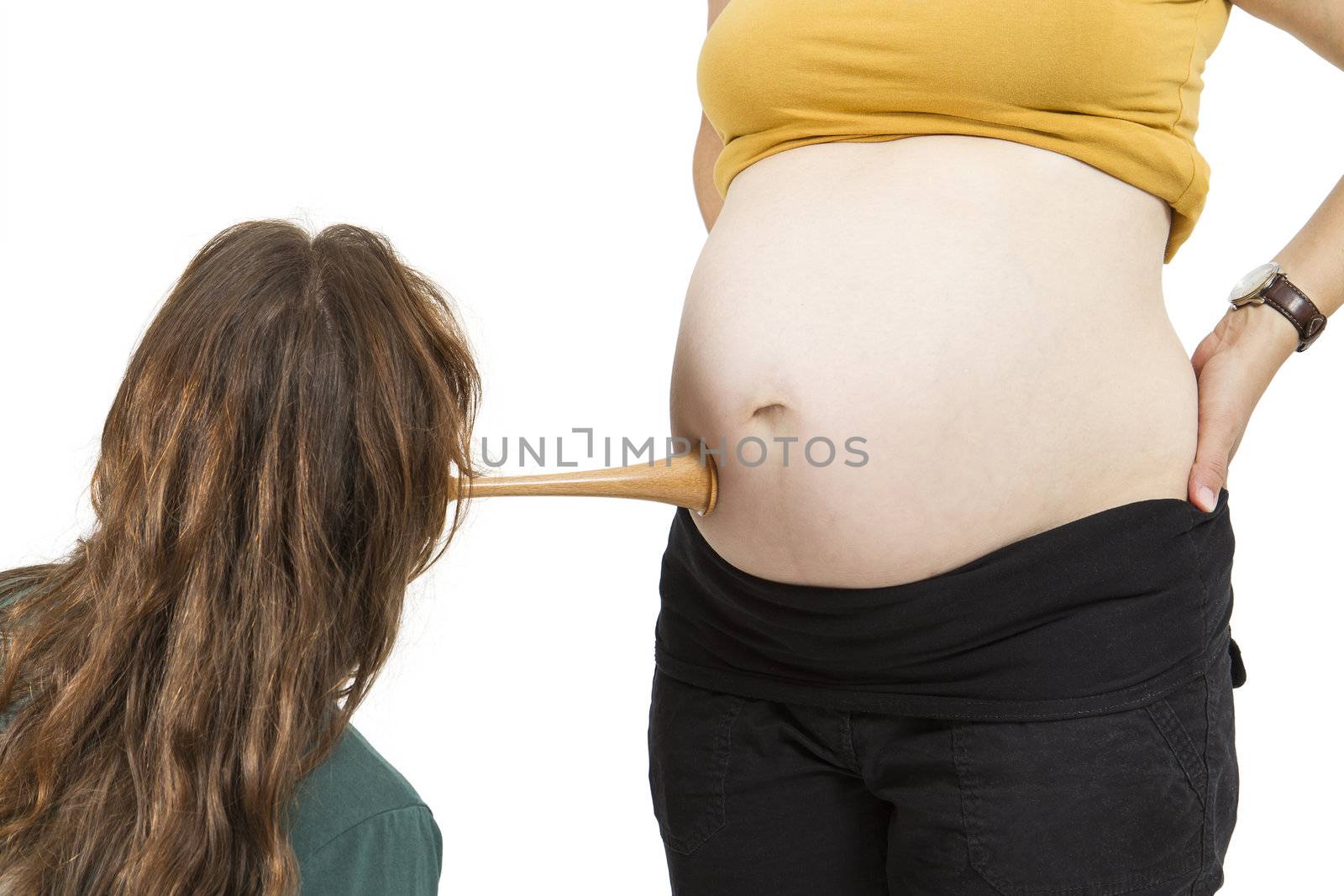 young midwife listening at human belly. pregnant woman standing while midwife is sitting in front. horizontal picture isolated on white