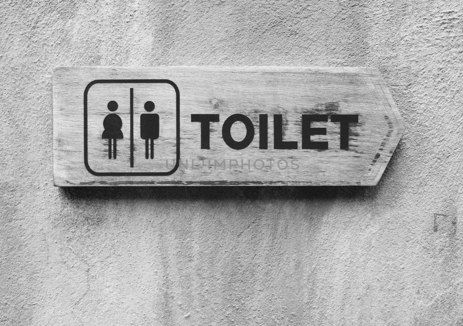 Ancient toilet sign on cement wall in black and white