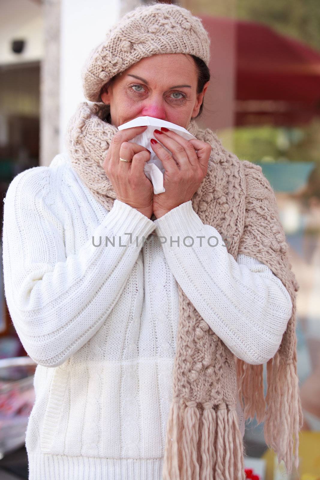 Elderly woman with a cold blows her nose