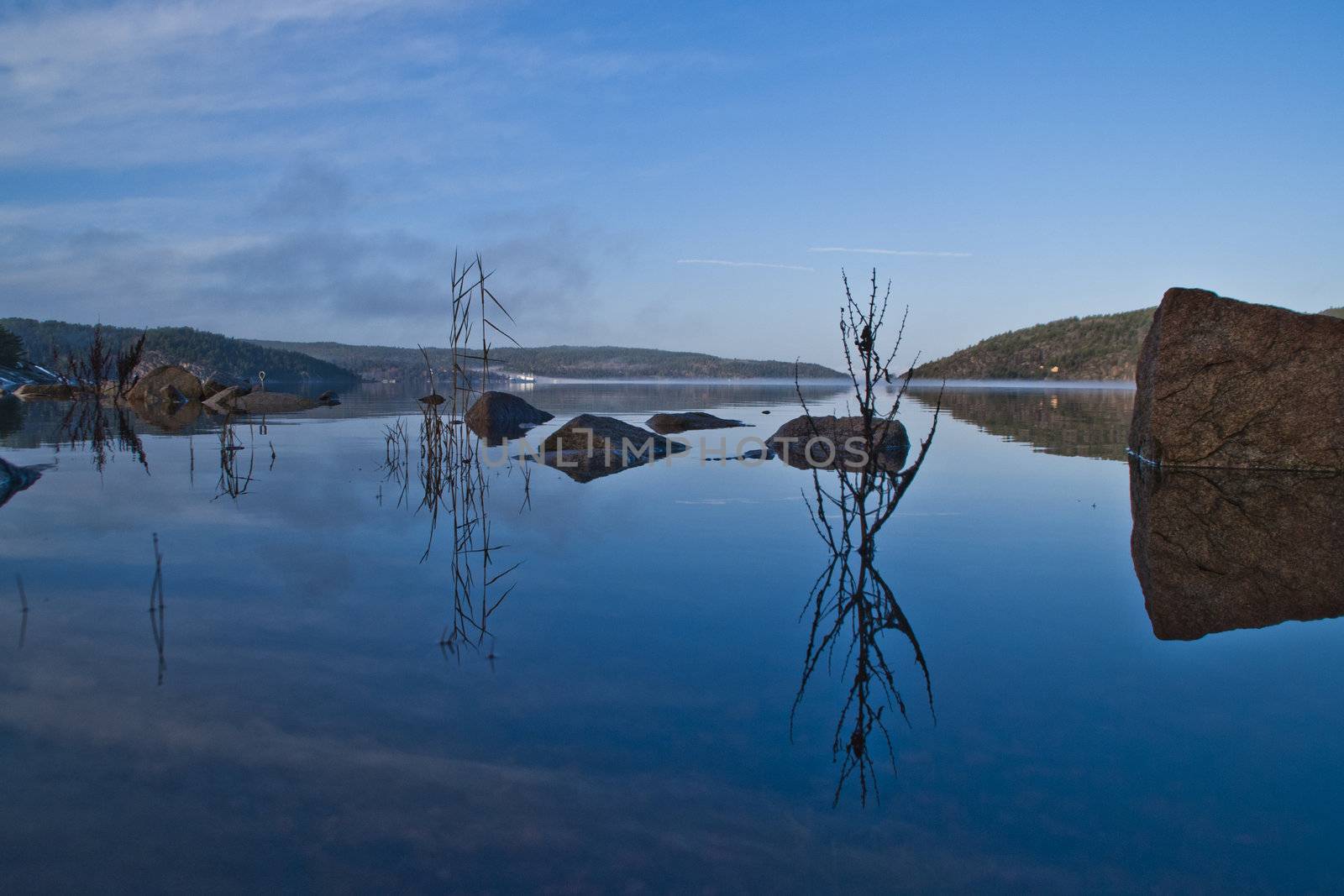 picture is shot in november 2012 with the camera down by the waterline, in the background seems the remnants of fog that earlier in the day lay thick over the entire fjord, iddefjord is a long fjord in halden municipality