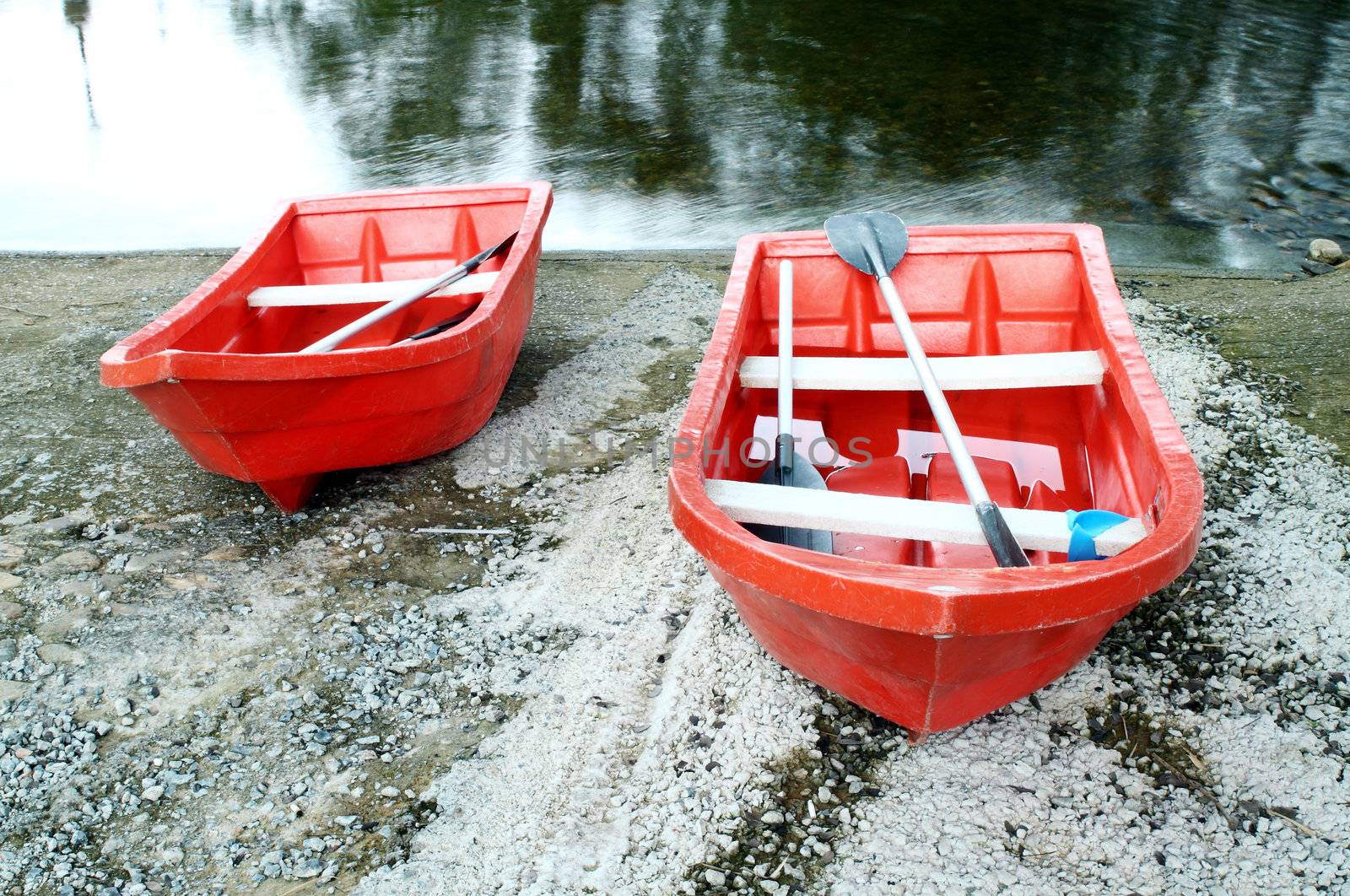 two red rowboat near the river