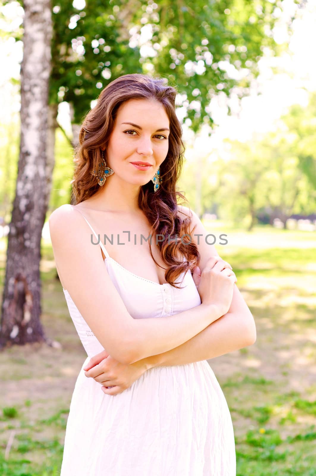 Portrait of an attractive woman in the park, crossed her arms