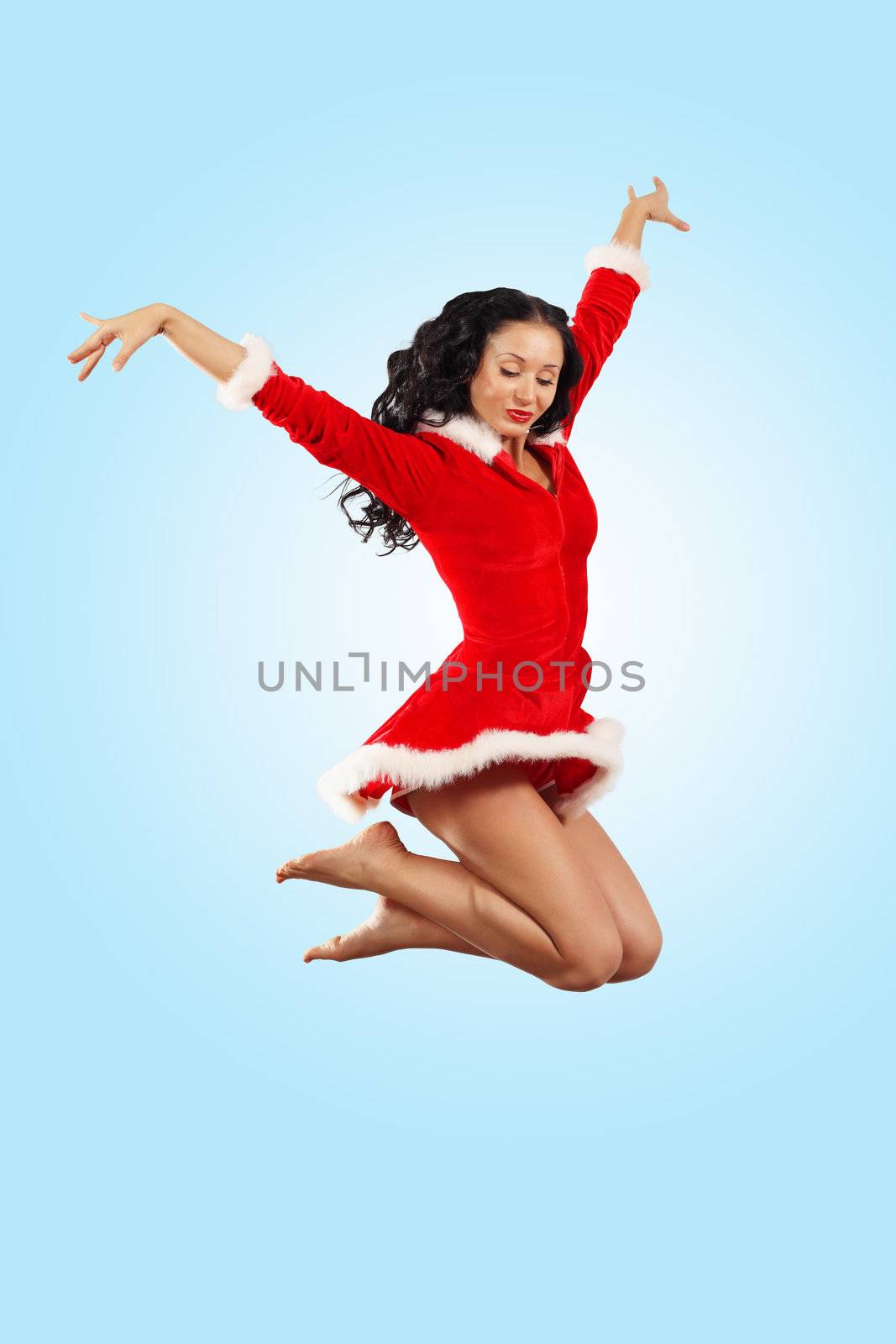 Happy smiling woman in red xmas costume jumping high