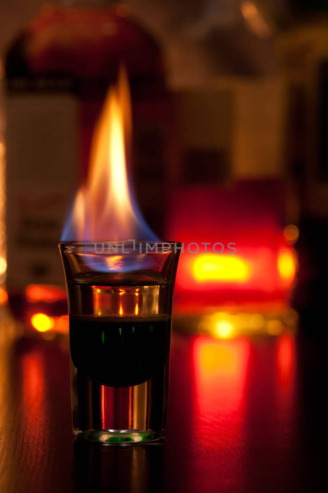 Burning cocktail in shot glass on a table, shallow focus