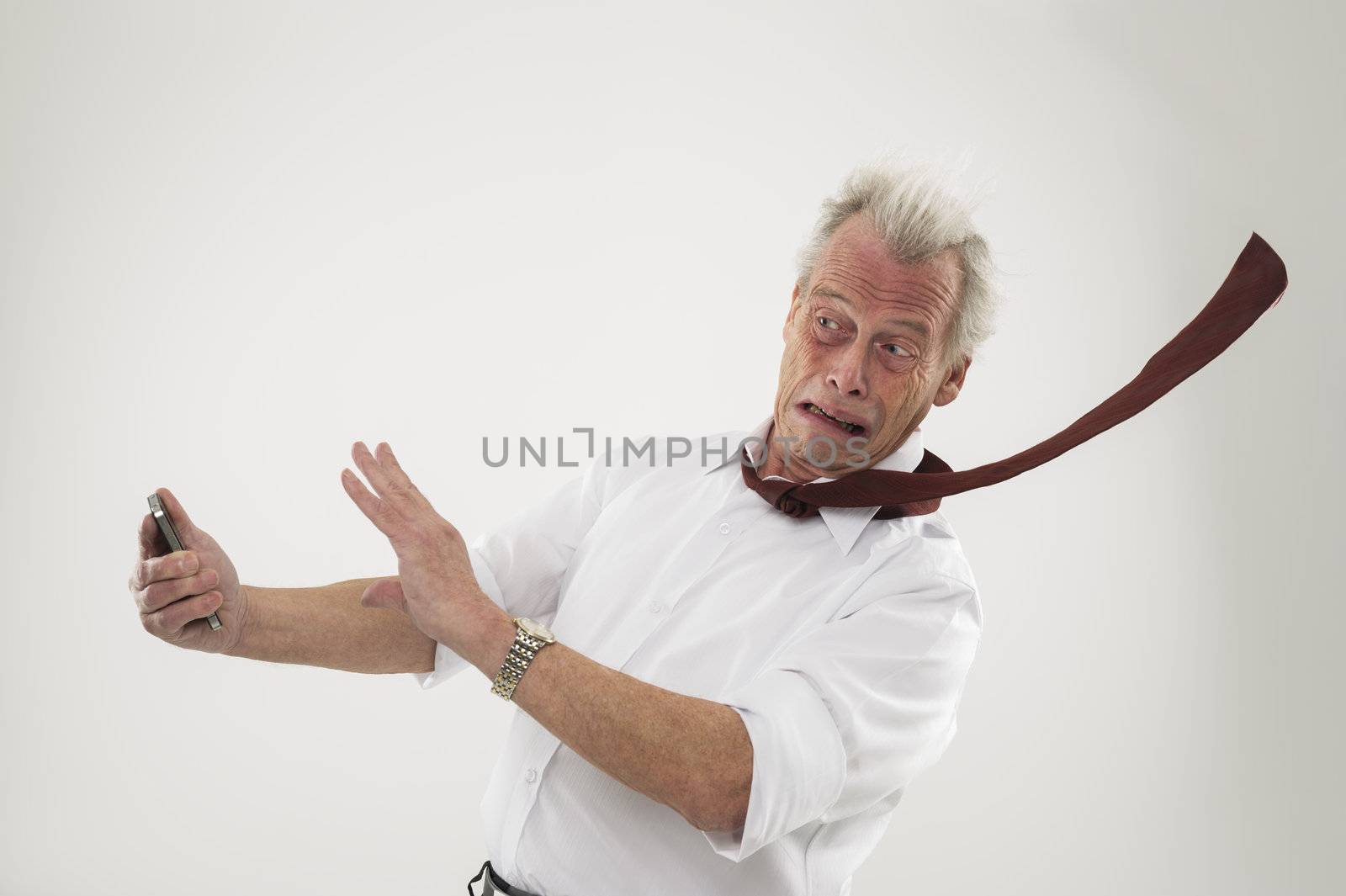 Businessman being battered by strong winds by MOELLERTHOMSEN