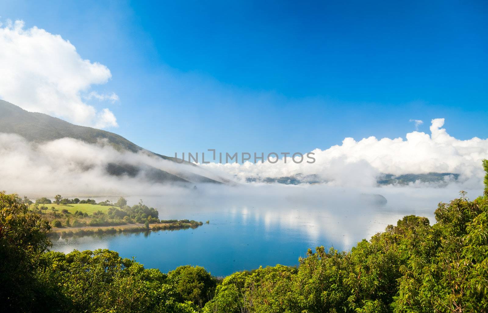 Clouds over Lake Rotoaria, New Zealand. Dots on water surface are swans